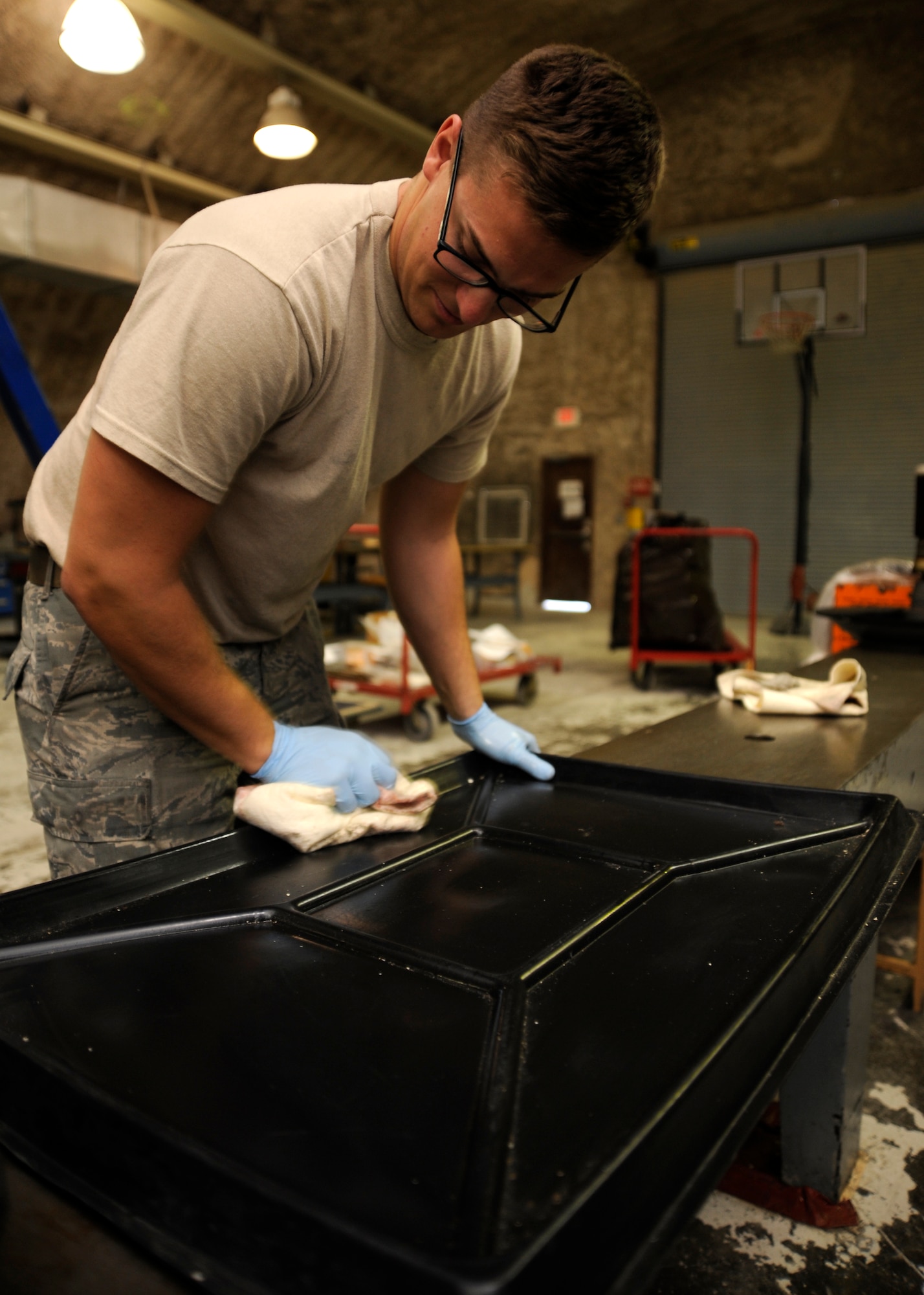 Staff Sgt. Cody Hauch cleans a drip pan during the final stages of breaking down the 379th Expeditionary Maintenance Squadron propeller centralized repair facility at the 379th Air Expeditionary Wing in Southwest Asia. Oct. 7, 2013. The propeller CRF was responsible for repairing all C-130H Hercules props throughout the U.S. Air Forces Central Command area of responsibility. Hauch is a 379th EMXS propeller CRF aerospace propulsion craftsman deployed from Little Rock Air Force Base, Ark., and a Henrietta, Texas, native. (U.S. Air Force photo/Senior Airman Bahja J. Jones) 