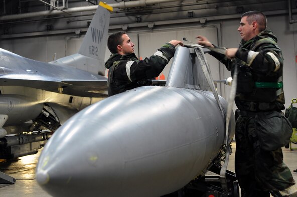 Airman 1st Class Nicholas Otlo, left, 35th Aircraft Maintenance Squadron, and Staff Sgt. Chance Cunningham, 35 AMXS, secure a wing fuel tank at Misawa Air Base, Japan, Oct. 9, 2013. Maintainers switched out an ejected fuel tank as part of a weeklong Operational Readiness Exercise. (U.S. Air Force photo by Senior Airman Derek VanHorn)