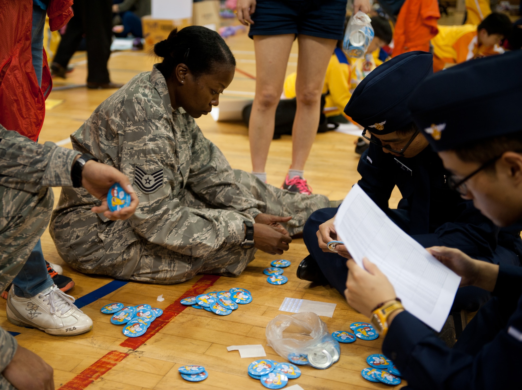 Tech. Sgt. Arlinia Drummonds, 8th Civil Engineer Squadron, sorts buttons during the Gunsan City Flower Painting Competition at Gunsan City, Republic of Korea, Oct. 8, 2013. This event was a chance for Airmen to mentor Gunsan children. (U.S. Air Force photo by Senior Airman Clayton Lenhardt/Released)