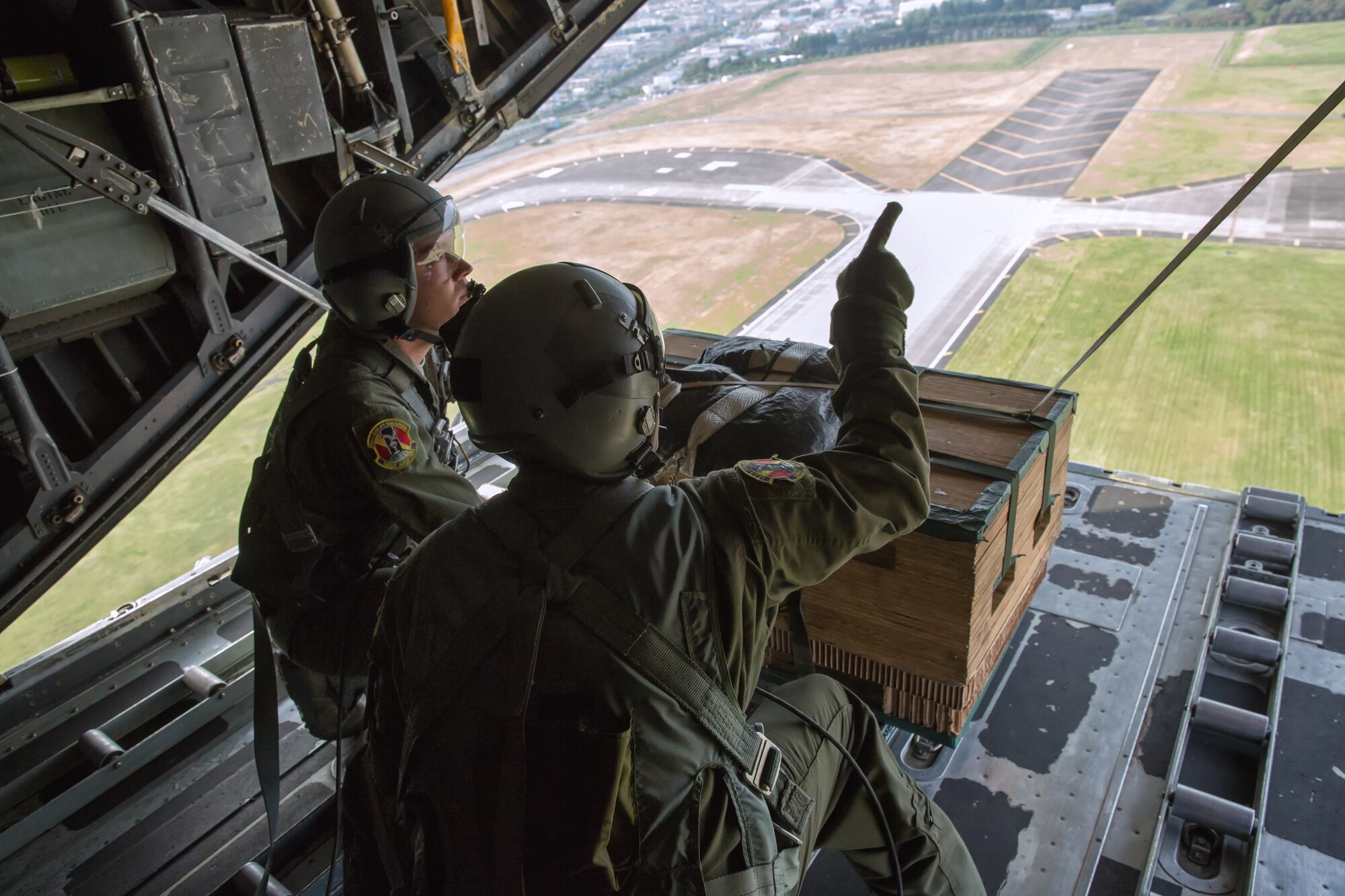 (From left to right) Airman 1st Class Andrew Fox and Tech. Sgt. Todd Bergin, loadmasters assigned to the 36th Airlift Squadron, prepare to deploy a low-cost, low-altitude payload during a Readiness Week training mission over Yokota Air Base, Japan, Oct. 8, 2013. Readiness Week focuses on Yokota's professional airlift mission and developing Airmen's ability to support any contingency in the Pacific. (U.S. Air Force photo by Osakabe Yasuo/Released)