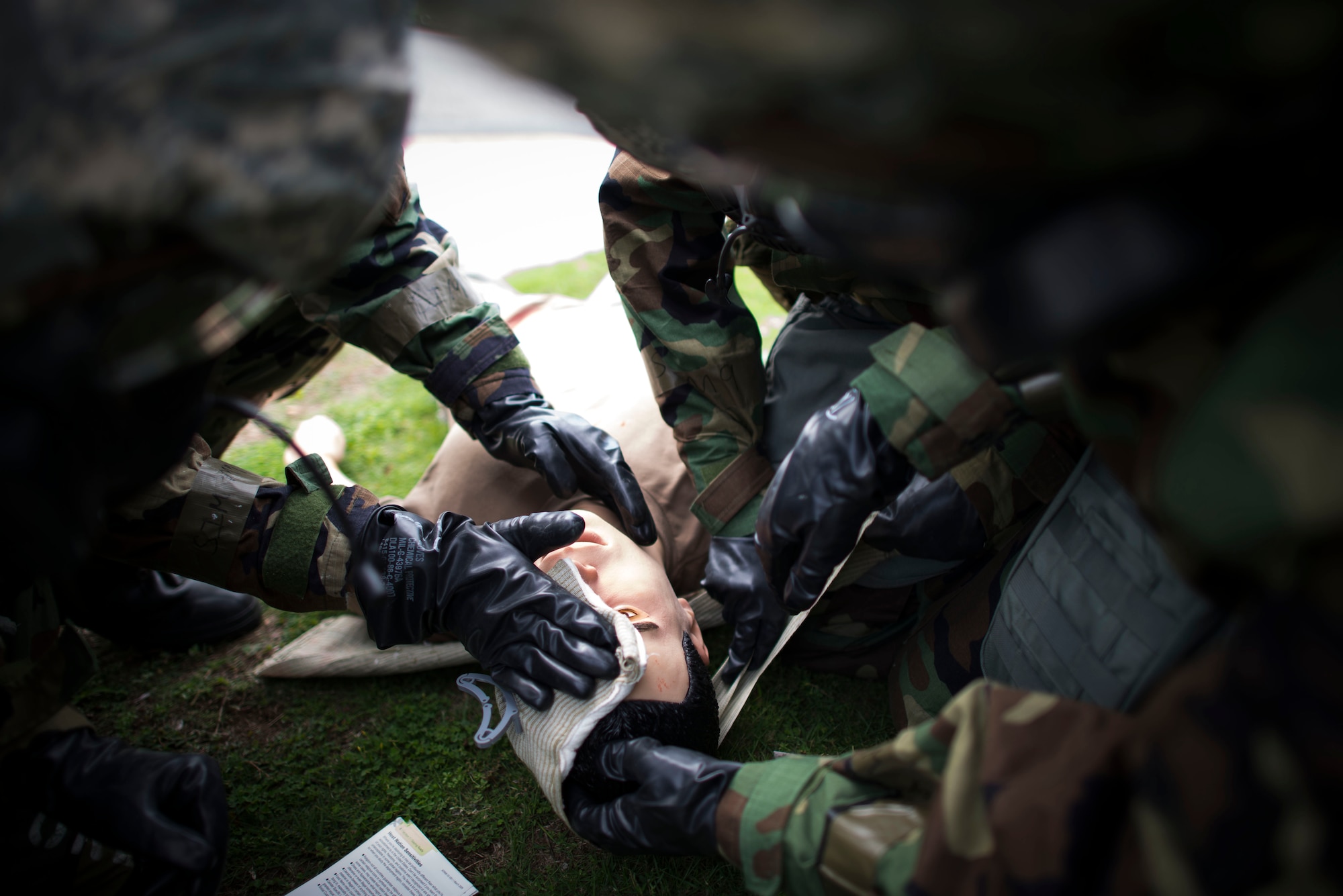374th Medical Group personnel apply a bandage to a simulated victim during ability to survive and operate (ATSO) training Oct. 9, 2013 at Yokota Air Base, Japan. ATSO training was held to reacquaint Airmen with basic contingency skills. (U.S. Air Force photo by Staff Sgt. Chad C. Strohmeyer/Released)