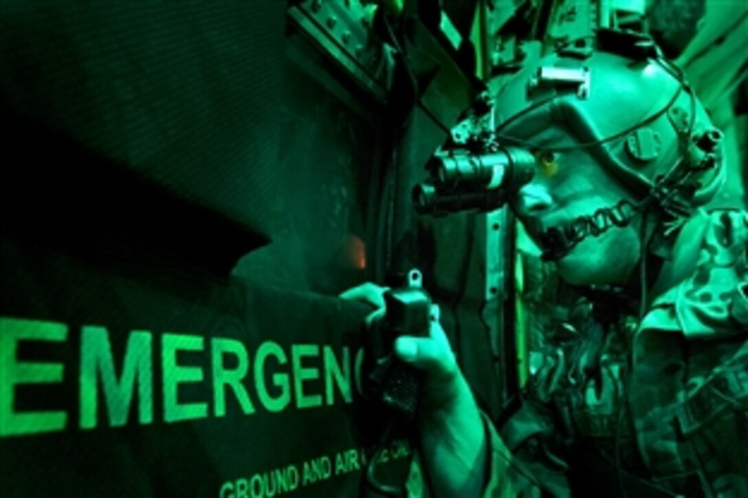 As seen through a night-vision device, U.S. Senior Airman Larry Webster scans for potential threats using night-vision goggles after completing a cargo airdrop in Ghazni province, Afghanistan, Oct. 7, 2013. Webster is a loadmaster assigned to the 774th Expeditionary Airlift Squadron.