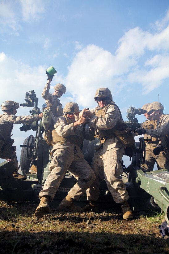 Lance Cpl. John R. Chiri, left, and Cpl. John J. Stubbs ram a 155 mm high-explosive round into the breech of an M777A2 155 mm lightweight howitzer at CATC Camp Fuji Oct. 2 as part of Artillery Relocation Training Program 13-3. Ramming the round is a two-man job, according to Stubbs. It takes a lot of strength and, through teamwork, Stubbs and Chiri are able to load the howitzer quickly. Chiri and Stubbs are field artillery cannoneers with the unit. (U.S. Marine Corps photo by Lance Cpl. Henry J. Antenor/Released)