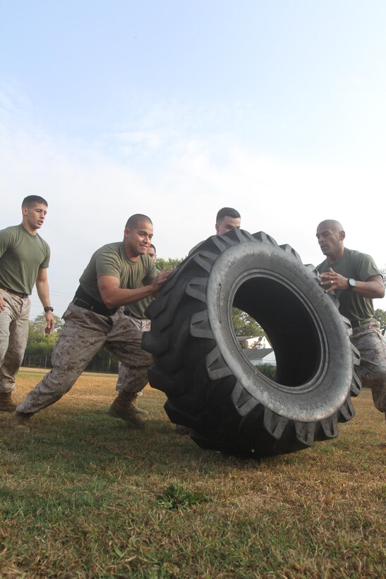 A team comprised of Marines assigned to the 1st Marine Corps District flips a tire during the 2nd Battalion, 25th Marine Regiment’s Field Meet on Oct. 4.  The event raised morale and promoted camaraderie for the Marines in attendance and gave them a chance to compete.  (U.S. Marine Corps photo by Pfc. Brandon Thomas).