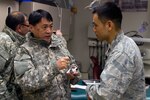 Mongolian Lt. Col. Elbegjargal Buyantogtokh (left) speaks to Air Force Capt. Alex Kwon, an optometrist from Joint Base Elmendorf-Richardson April 15, 2012. Buyantogtokh is an optometrist with the Mongolian Armed Forces who travelled to Alaska to see operations during Arctic Care 2012.