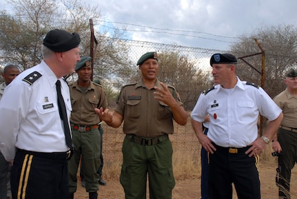 Army Sgt. Major Kamodi, noncommissioned officer in charge of the Botswana Defence Force Wildlife Training Center, explains to Army Maj. Gen. Greg Lusk, adjutant general of the North Carolina National Guard and Army Maj. Gen. Edward Leacock of the Defense Intelligence Agency, how they train BDF Soldiers to react to various predators to prepare Botswana soldiers to conduct patrols in the bush areas of the country in November 2011. The North Carolina National Guard and Botswana are partners through the National Guard State Partnership Program.