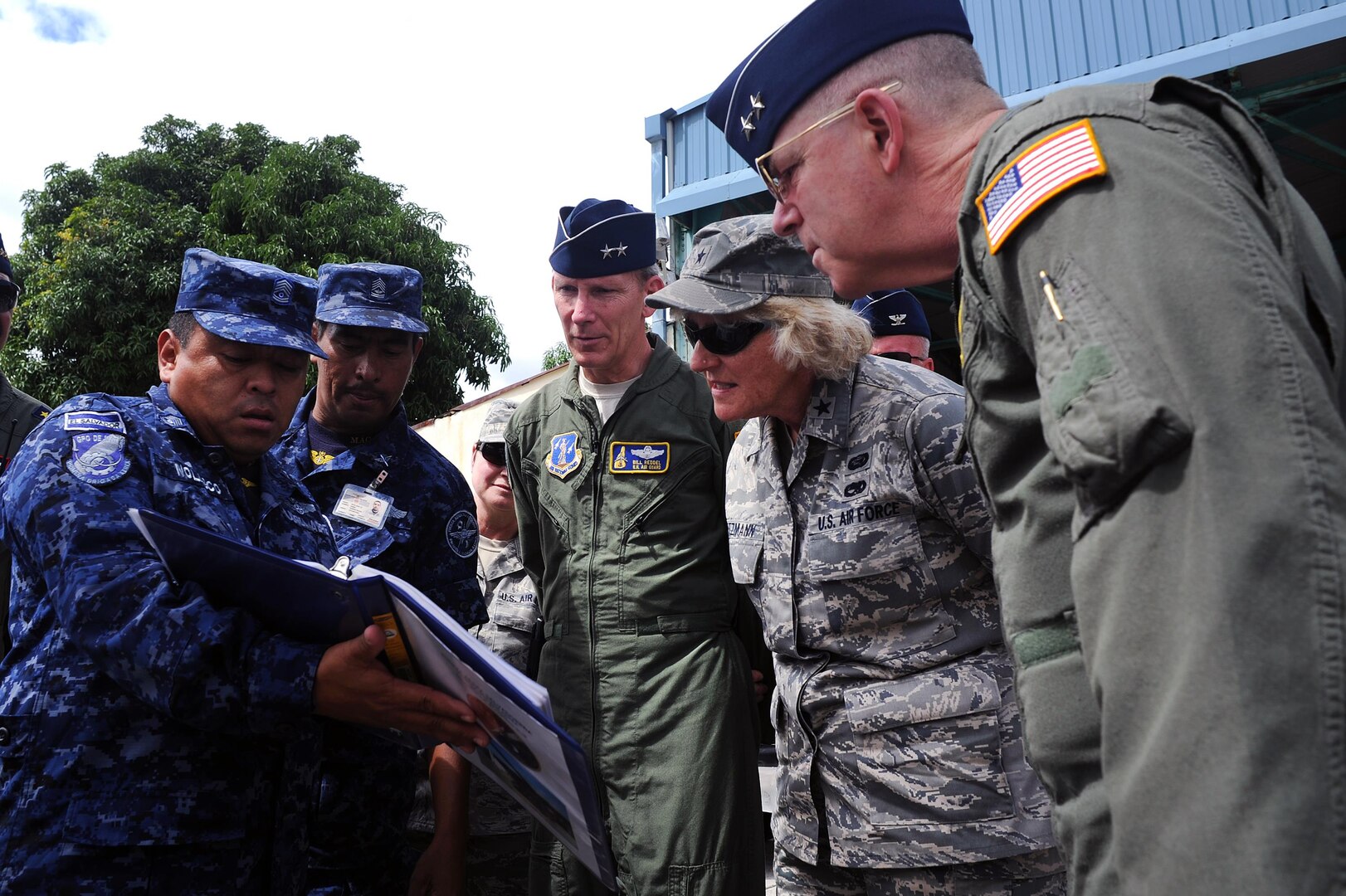 U.S. Air Force Maj. Gen. William Reddel III, center, in flight suit, adjutant general of the New Hampshire National Guard, and other senior leaders from the New Hampshire Guard look over maintenance records while visiting with members of the El Savadoran 1st Air Brigade near San Salvador, El Salvador, Jan. 27, 2012. Reddel met with Salvadoran military officials as part of the State Partnership Program, which builds relationships between the National Guard in the states and territories and partnered nations worldwide. New Hampshire is in its 12th year of partnering with El Salvador.