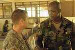 U.S. Army Lt. Col. John Wojcik, left, staff judge advocate, Joint Force Headquarters, Michigan National Guard, talks to an Armed Forces of Liberia soldier during a break in instruction during a three-week legal training course at Edward Binyah Kesselly Military Barracks, Liberia, Jan 23, 2011. About 50 AFL service members, including military police officers, investigators and paralegals, completed the three-week course that taught basics in detainee operations and military law procedures, among other topics. The legal training was one in a series of capacity building events designed to promote the developing AFL, which is being retrained and reequipped following several years of national strife.