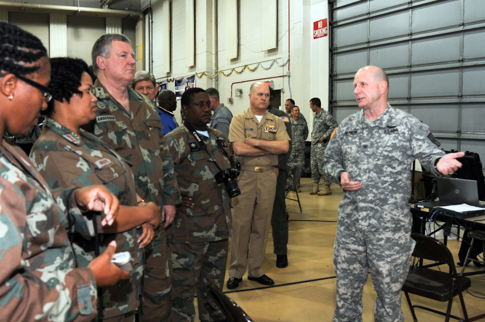 Army Col. Craig Meinking, a member of the New York Army National Guard, explains New York Army National Guard health-check procedures to South African Maj. Gen. Roy Andersen (center) and other South African National Defense Force Reserves officers during a Dec. 1, 2010 visit in Latham, N.Y.