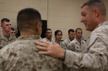 Chief Petty Officer Carolina L. Bejarano (center), the wife of Sgt. Julian Bejarano Jr., a mortarman with the Battle Skills Training School, Combat Logistics Regiment 27, 2nd Marine Logistics Group, watches while Col. Gary F. Keim, the commanding officer of CLR-27, speaks about her husband during his Purple Heart award ceremony aboard Camp Lejeune, N.C., Oct. 8, 2013. Julian received the Purple Heart Medal in recognition of wounds he sustained in Helmand province, Afghanistan, July 5, 2013. 
