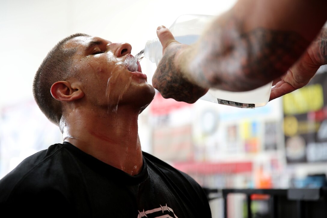 Lance Cpl. Oscar Kush, mortarman, Weapons Company, 1st Battalion, 1st Marine Regiment, and a native of Chicago, takes a quick water break before resuming his training session during a Mixed Martial Arts class in Oceanside, Calif., Oct. 3, 2013. He said the training is rigorous and requires his body to be constantly hydrated. Kush transfers his skills as a Marine to MMA to better his fighting abilities. He has been training for 10 months and plans on making MMA a career.