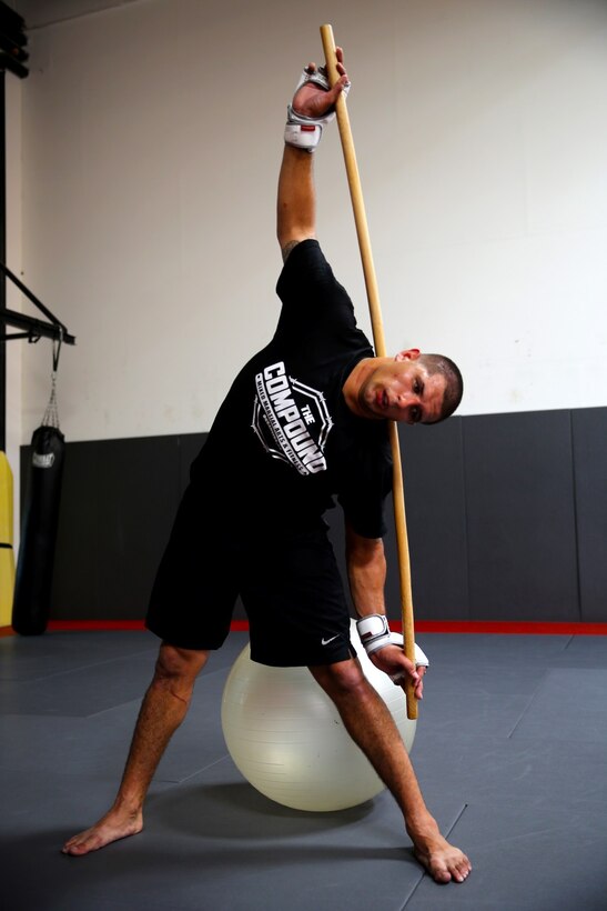 Lance Cpl. Oscar Kush, mortarman, Weapons Company, 1st Battalion, 1st Marine Regiment, and a native of Chicago, stretches after training at a Mixed Martial Arts class in Oceanside, Calif., Oct. 3, 2013. Stretching helps Kush recover faster after a rigorous training session. MMA training helps relieve Kush's day-to-day stress of being an infantryman. Kush has been in two MMA fights and has not lost a match.