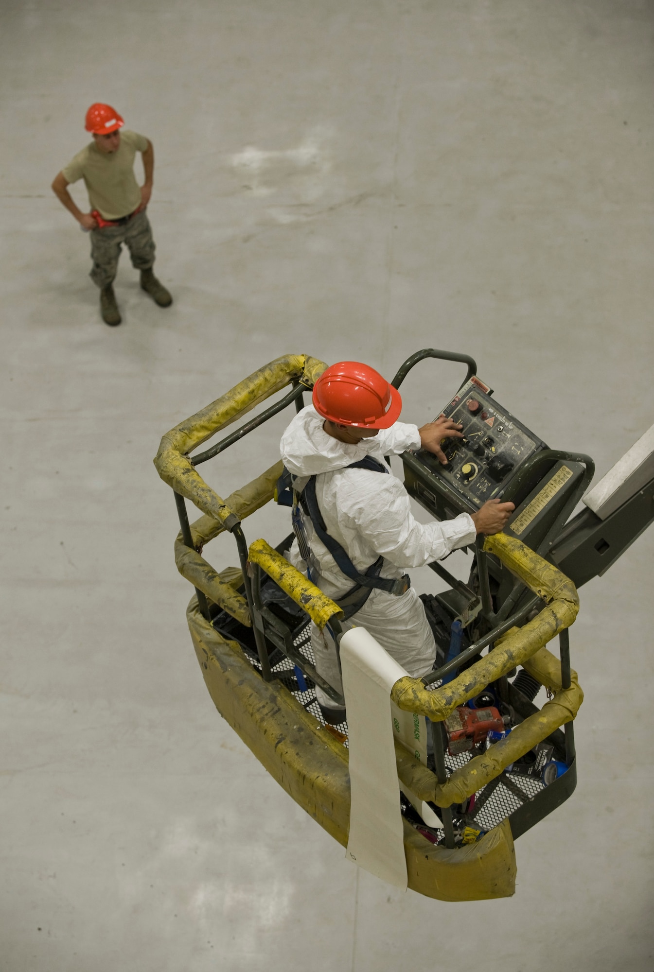Airmen from the 22nd Maintenance Squadron work together while operating a JLG Lift, Oct. 2, 2013, at McConnell Air Force Base, Kan. Structural maintenance Airmen are required to wear safety harness when performing tasks while elevated. (US Air Force photo/Airman 1st Class John Linzmeier)