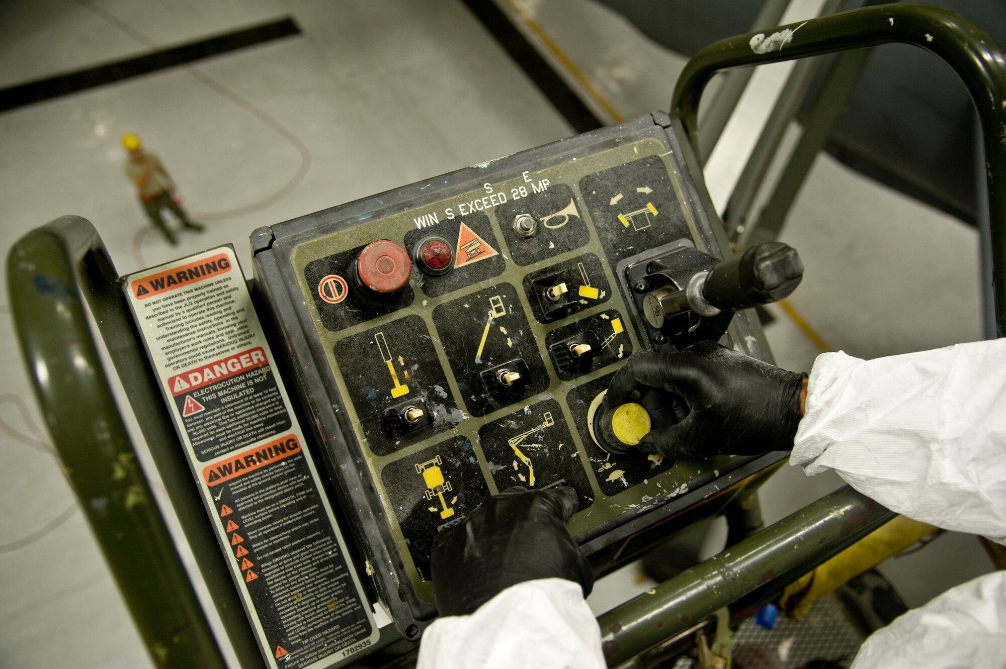 Communication between an operator and spotter is required to use a JLG Lift safely. The spotter carries an air-horn to signal the operator, helping prevent a collision. The lift is capable of extending 40 feet upwards. (US Air Force photo/Airman 1st Class John Linzmeier)