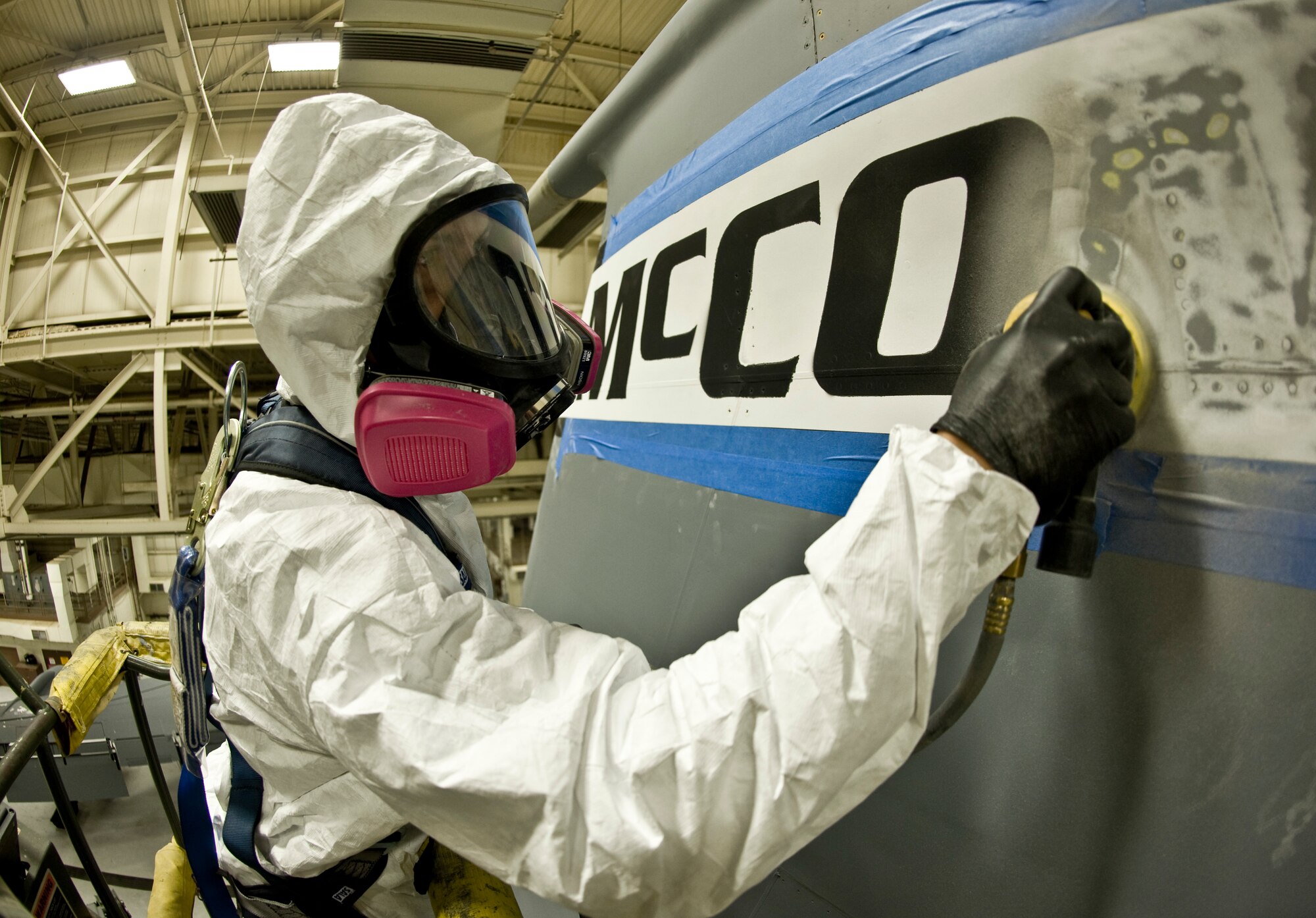 Airman 1st Class Eric Amato, 22nd Maintenance Squadron aircraft structural maintenance apprentice, sands the McConnell insignia off the vertical stabilizer of a KC-135 Stratotanker Sept. 30, 2013, at McConnell Air Force Base, Kan. He wears personal protective equipment to protect himself from paint particles as he removes paint. (US Air Force photo/Airman 1st Class John Linzmeier)