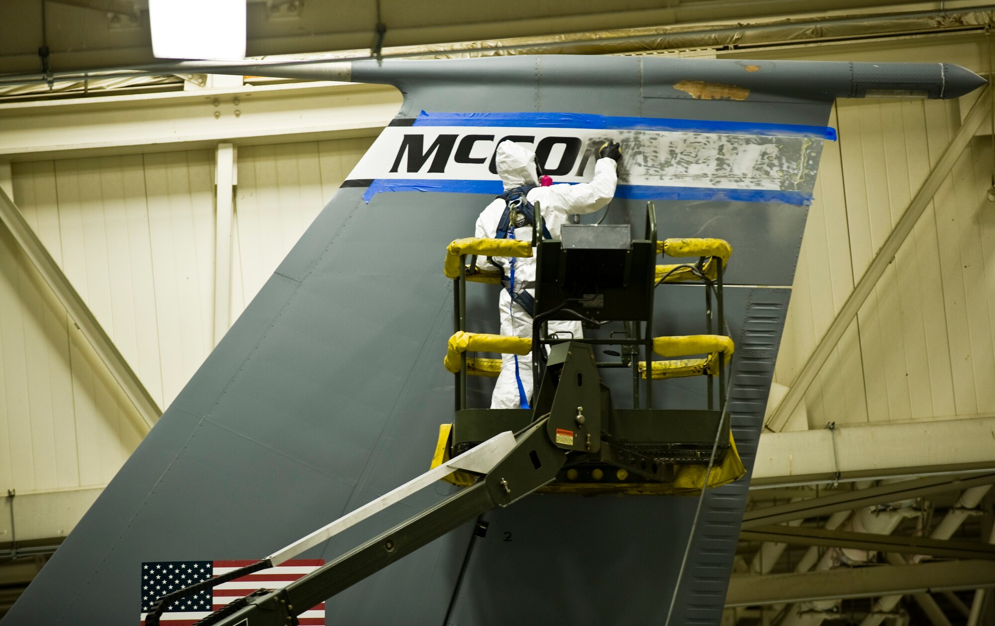 Airman 1st Class Eric Amato, 22nd Maintenance Squadron aircraft structural maintenance apprentice, sands the McConnell insignia on off the vertical stabilizer of a KC-135 Stratotanker Sept. 30, 2013, at McConnell Air Force Base, Kan. Old markings are repainted with updated dimensions so that all McConnell aircraft match. (US Air Force photo/Airman 1st Class John Linzmeier)