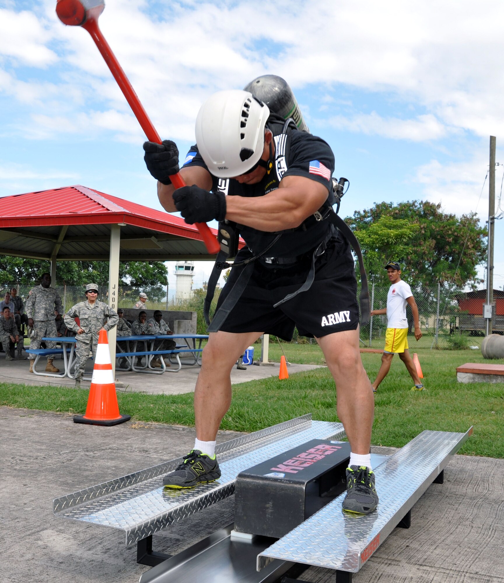 U.S. Army 1st Sgt. Thinh Huyne uses a rubber sledgehammer to advance a Keiser sled during a Fire Muster at Soto Cano Air Base, Honduras, Oct. 10, 2013. The Fire Muster was conducted by the Fire and Emergency Services at the base in order to bring awareness to Fire Prevention Week. (U.S. Air Force photo by Capt. Zach Anderson) 

