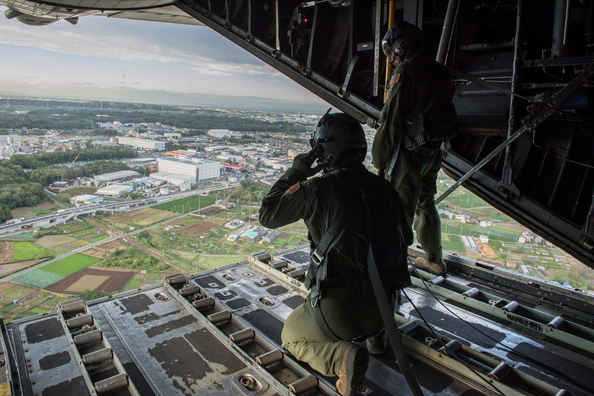 Loadmasters assigned to the 36th Airlift Squadron peer out of the back of a C-130 Hecules as they practice a low altitude flight during Readiness Week, Oct. 9, 2013, at Yokota Air Base, Japan. Yokota’s airlifters provide rapid tactical airlift support throughout the pacific theater. (U.S. Air Force photo by Senior Airman Michael Washburn/Released)