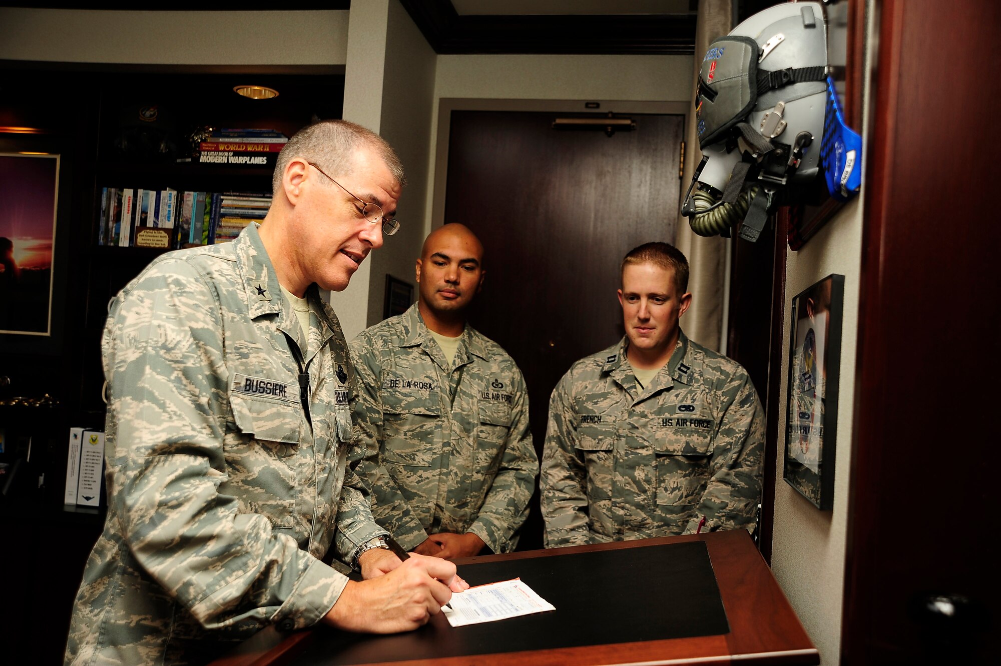 U.S. Air Force Brig. Gen. Thomas A. Bussiere, 509th Bomb Wing commander, signs his Combined Federal Campaign pledge card Oct. 2, 2013, at Whiteman Air Force Base, Mo., as CFC coordinators Master Sgt. John De La Rosa, middle, and Capt. Kenneth French look on. Whiteman’s goal for this year’s campaign is $140,000. For more information about the CFC, visit www.heartlandcfc.org. (U.S. Air Force photo by Staff Sgt. Brigitte N. Brantley/Released)