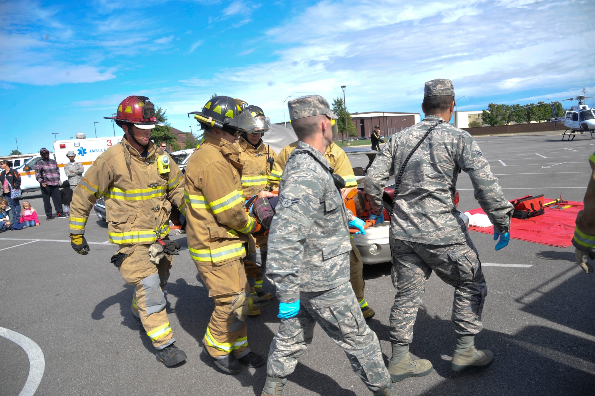 U.S. Air Force 509th Civil Engineer Squadron firefighters and a 509th Medical Group ambulance response team demonstrate rescue procedures at Whiteman Air Force Base, Mo., Oct. 5, 2013. This demonstration during Fire Prevention Week showed how the units work together to respond to car accidents. (U.S. Air Force photo by Airman 1st Class Keenan Berry/Released)