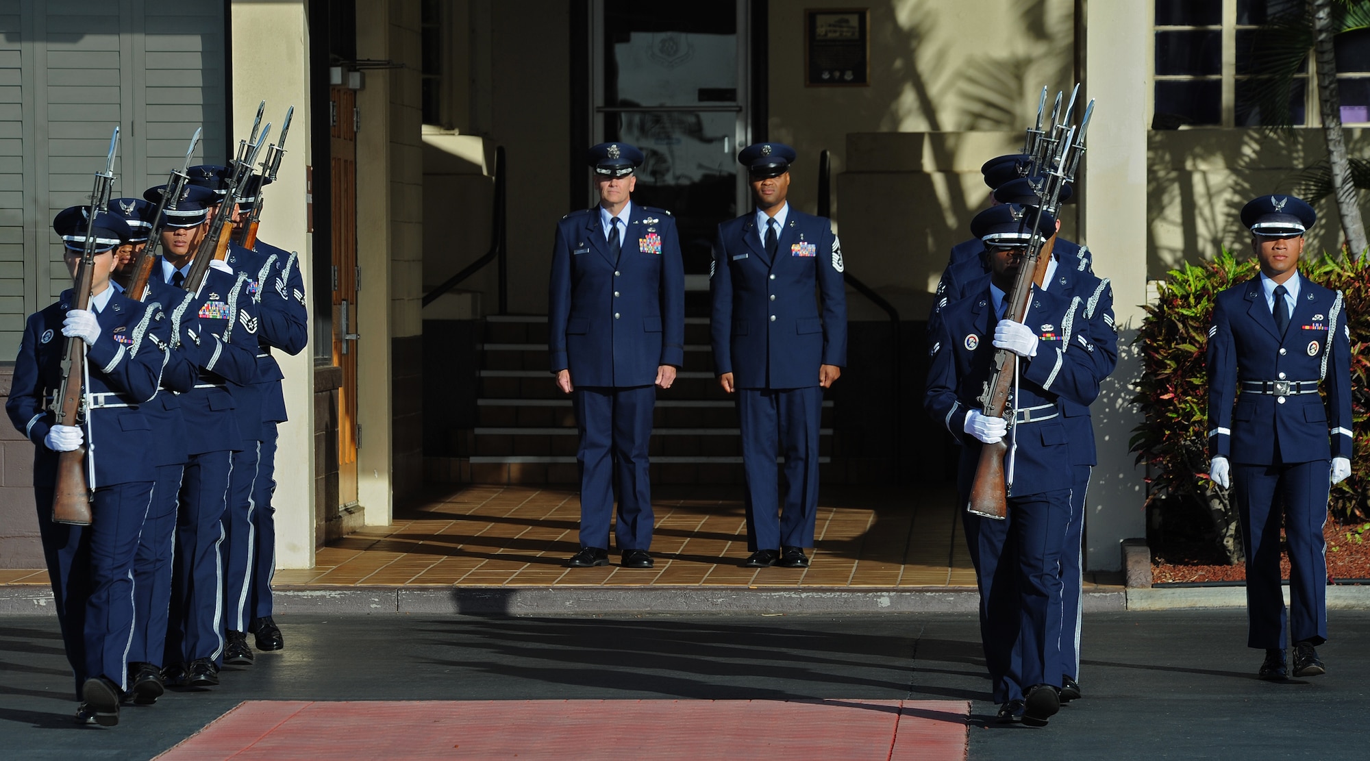 Col. Johnny Roscoe, 15th Wing commander, Chief Master Sgt. Leslie Bramlett, 15th Wing command chief, center, practices a scene during the filming of a portion of “Hawaii Five-0,” in front of the base operation, Joint Base Pearl Harbor-Hickam, Hawaii, Oct. 9, 2013. The crew and cast were on scene to shoot a portion of an upcoming episode. (U.S. Air Force photo/Tech. Sgt. Jerome S. Tayborn)