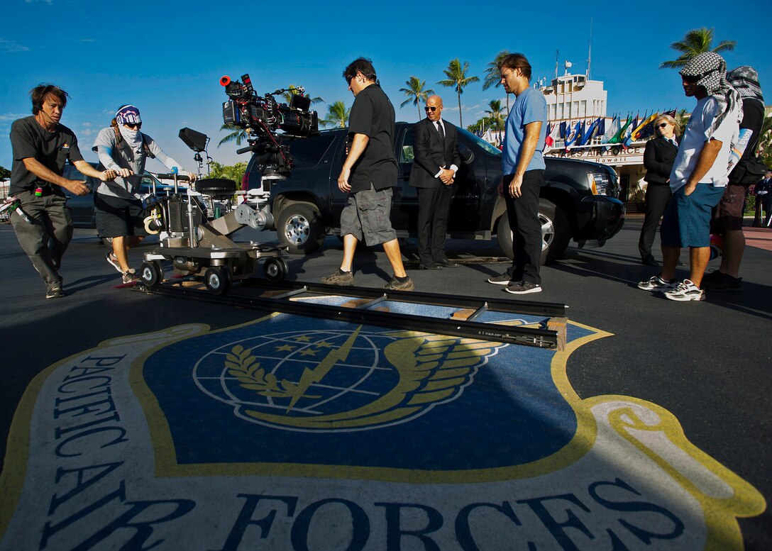 "Hawaii Five-0" production crew members set up a scene on the flightline during the filming of a portion of a scene at base operation center, Joint Base Pearl Harbor-Hickam, Hawaii, Oct. 9, 2013. The crew and cast were on scene to shoot a portion of an upcoming episode. (U.S. Air Force photo/Tech. Sgt. Jerome S. Tayborn)