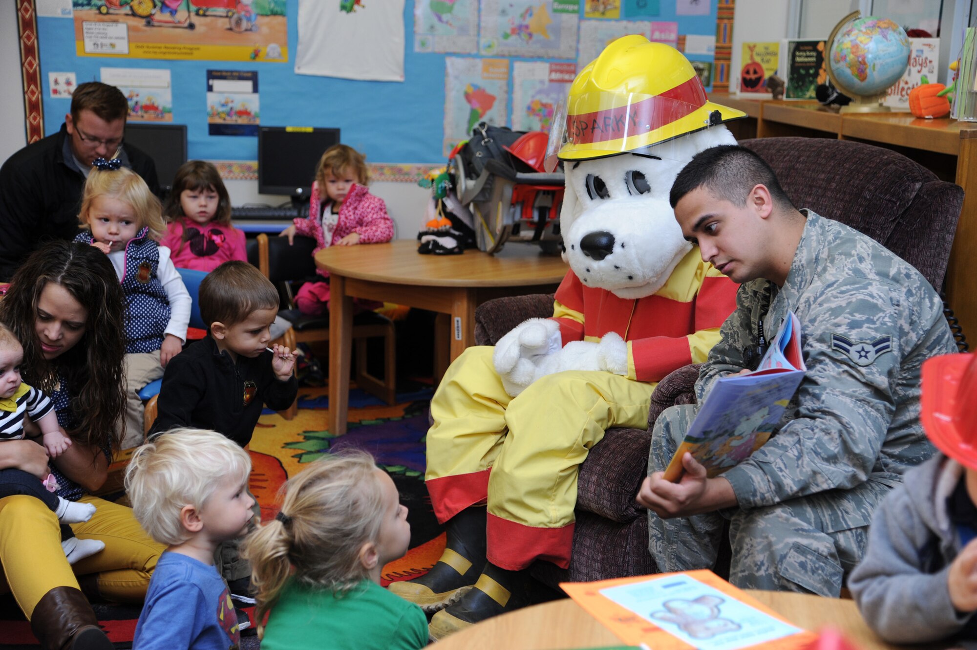 Airman 1st Class Zachary Torres, 341st Civil Engineer Squadron member, and Sparky the Fire Dog read a storybook to children at the Malmstrom Air Force Base Library on Oct. 8 in celebration of Fire Prevention Week. The week-long celebration runs through Oct. 12 and includes fire educational displays, a fire muster competition and a parade. Look for more photos of the week-long event in next week’s edition of the Global Guardian.  (U.S. Air Force photo/Senior Airman Katrina Heikkinen)