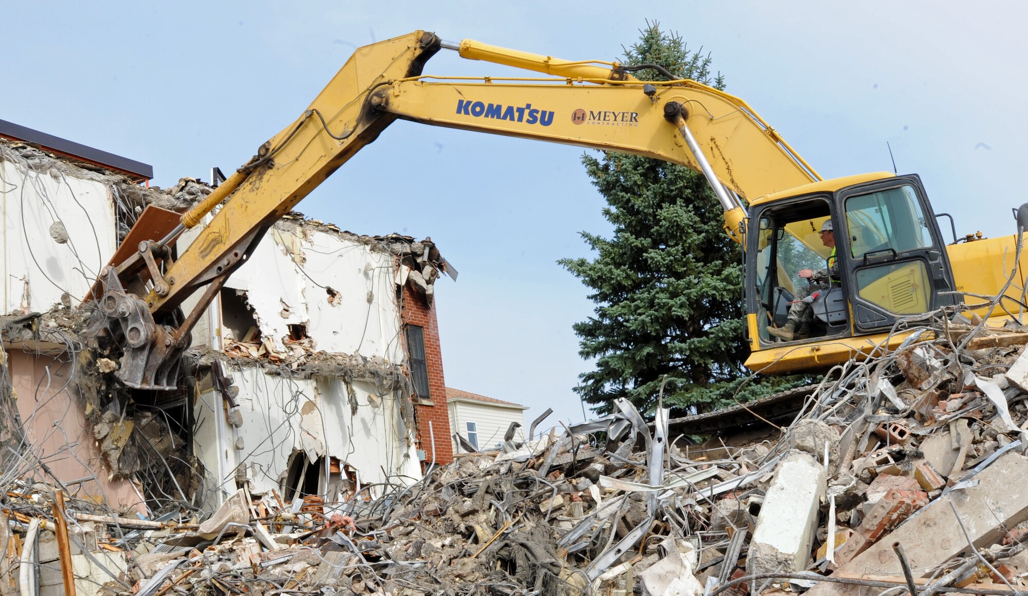 Col. Alex Mezynski, 5th Bomb Wing commander, recently rode the wheel of an excavator for opportunity to take part in the demolishing of Dorm 215 at Minot Air Force Base, N.D. Dorm 215 was originally built in 1958. With the demolishing of this dorm, it leaves only one dormitory left scheduled for demolition. (U.S. Air Force photo/Senior Airman Jose L. Hernandez)
