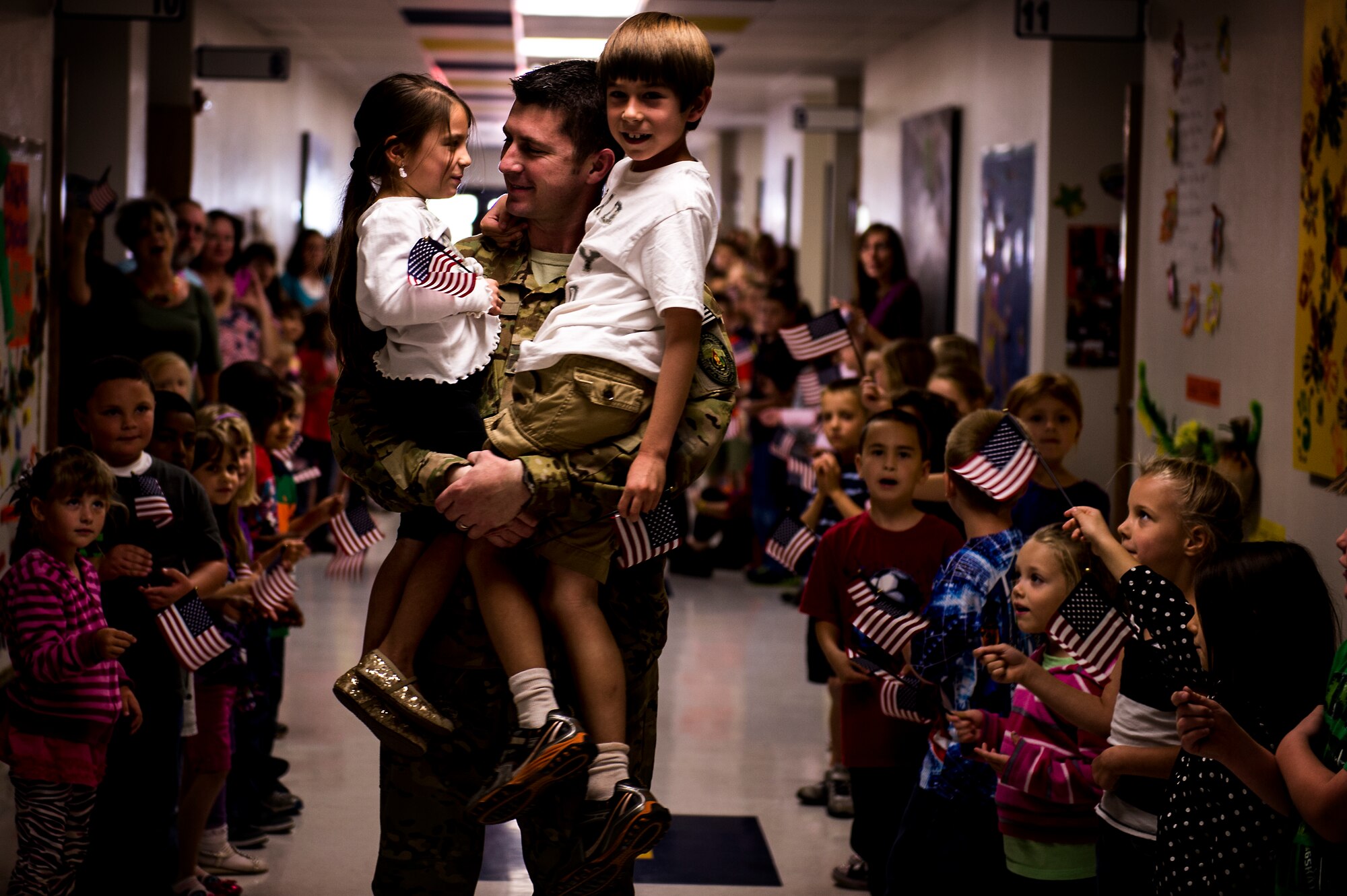 U.S. Air Force Major Robert Bingham reunites with his children Zach and Isabella after receiving a hero's welcome through the halls of Clovis Christian school Oct. 8, 2013. Bingham's arrival marked the end of a four-month long deployment away from his family to Afghanistan. (U.S. Air Force photo/ Staff Sgt. Matthew Plew)(RELEASED)