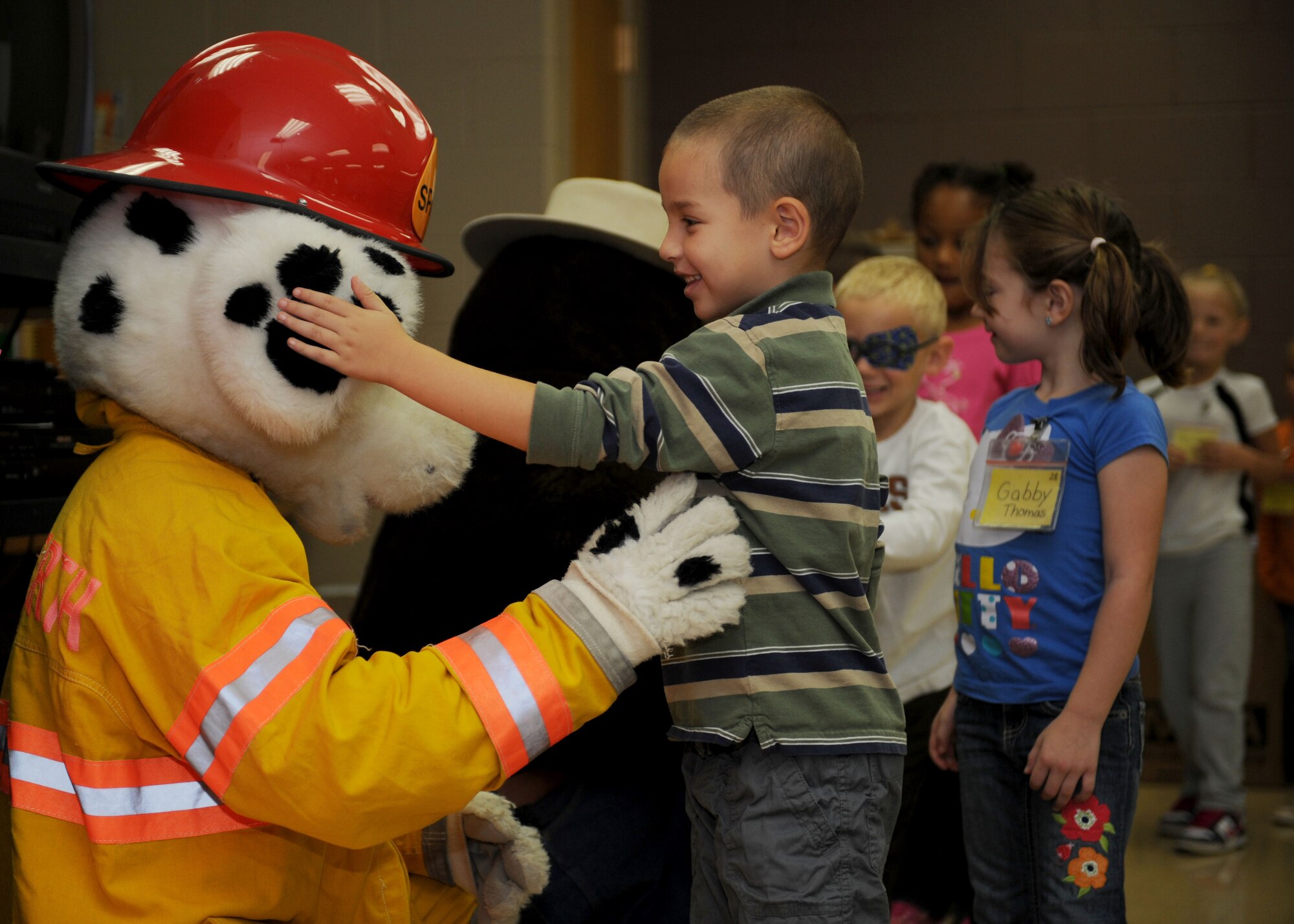 Kindergarten students meet Sparky the Dog and Smokey the Bear during a fire prevention presentation at Badger Clark Elementary School in Box Elder, S.D. Oct. 3, 2013. During the day, students learned how to prevent house fires and contact emergency responders in the event of a fire. (U.S. Air Force photo by Airman 1st Class Rebecca Imwalle/Released)