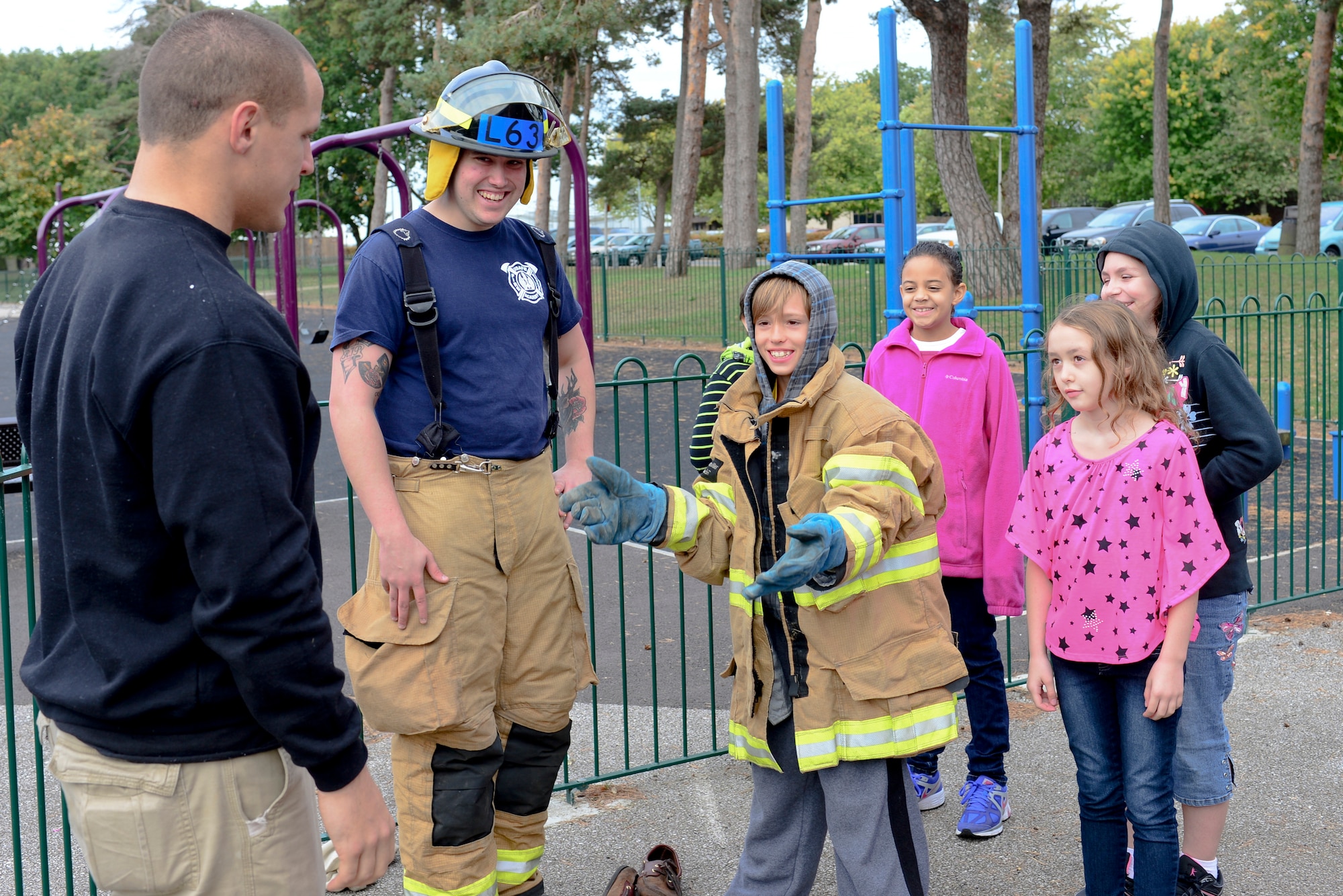Fourth grader Baylee Jost, son of Master Sgt. Donald Jost, 48th Logistics Readiness Squadron tries on firefighter gear at the intermediate school at Royal Air Force Lakenheath, England, Oct. 8, 2013. Firefighters from the Suffolk Fire and Rescue Service worked with 48th Civil Engineering Squadron firefighters to help raise awareness about fire safety as a part of National Fire Prevention Week. (U.S. Air Force photo by Airman 1st Class Dana J. Butler/Released)