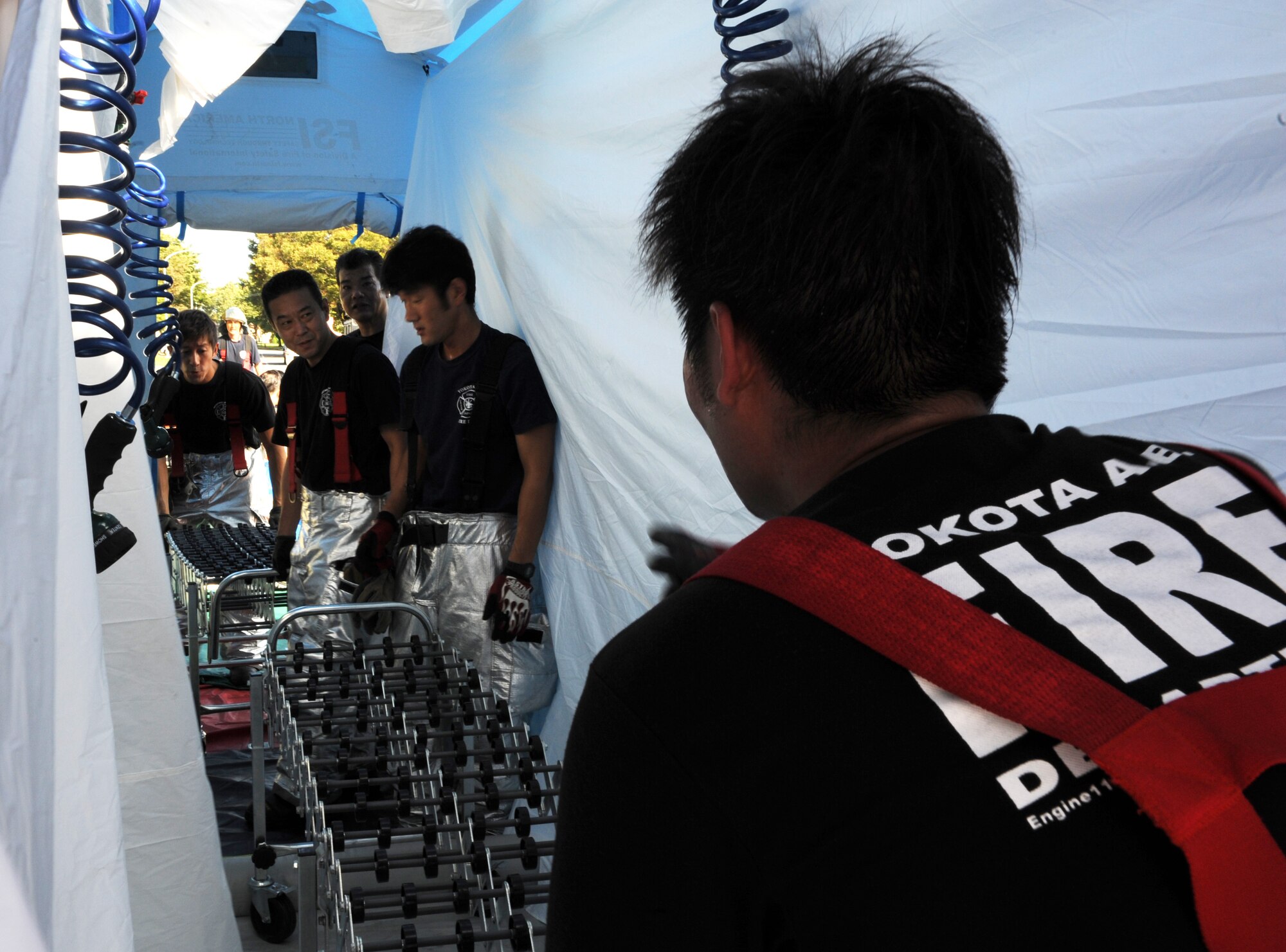 Firefighters from the 374th Civil Engineer Squadron set up a decontamination tent during an emergency management exercise Oct. 10, 2013, at Yokota Air Base, Japan. The training allowed first responders to practice their skills in responding to an emergency scenario, and was conducted as part of wing-wide training during Readiness Week (U.S. Air Force photo by Senior Airman Desiree Economides/Released)