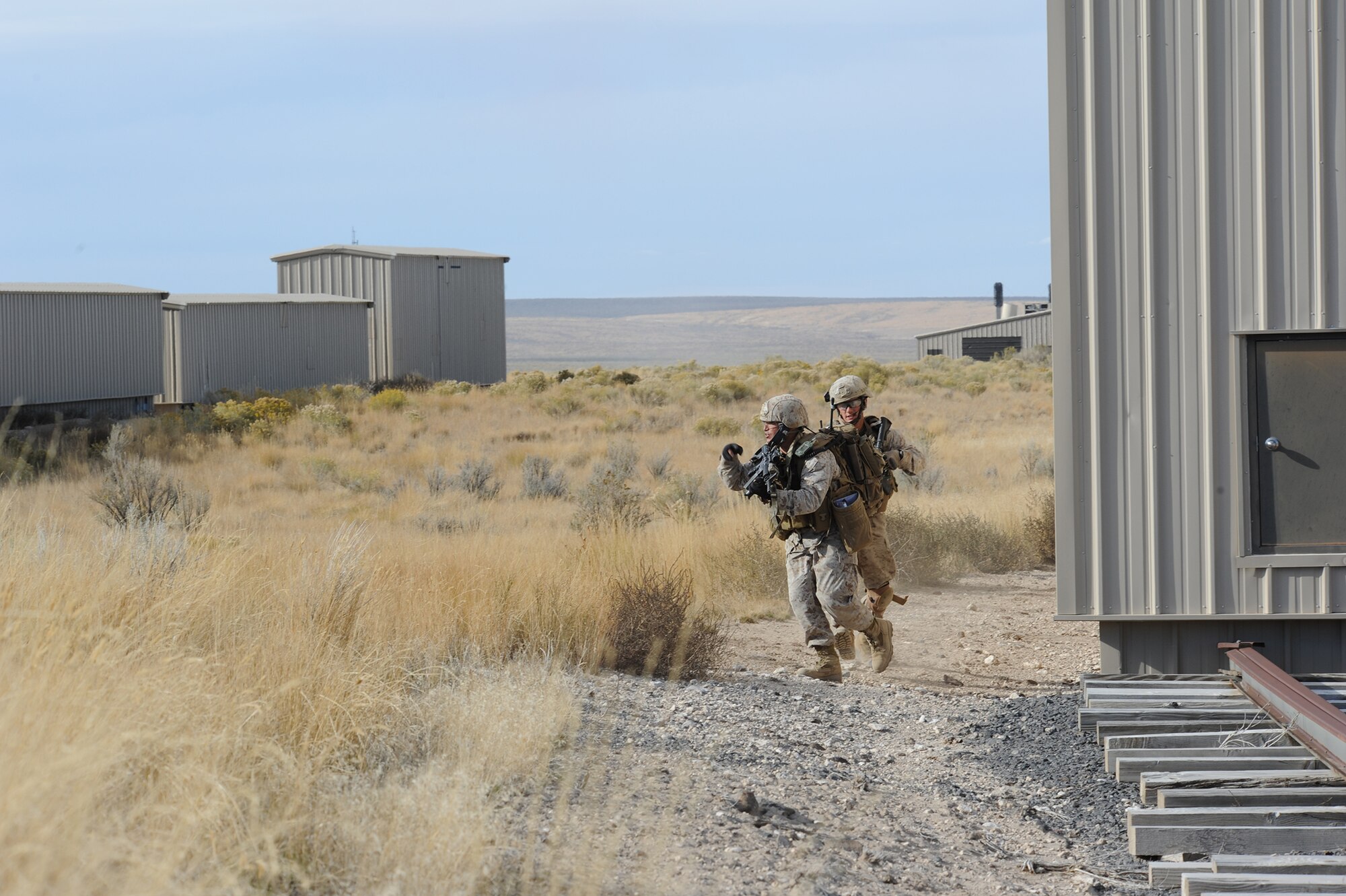 U.S. Marine Capt. Erich Lloyd (front) and Cpl. Andrew Dimauro, 1st Air Naval Gunfire Liaison Company forward air controllers deployed from Camp Pendleton, Calif., assault an enemy objective during exercise Mountain Roundup 2013 at Juniper Butte Range, about 70 miles from Mountain Home Air Force Base, Idaho, Oct. 8, 2013. Lloyd, a prior-enlisted crew chief, used U.S. Navy AV-8B Harriers and Republic of Singapore Air Force F-15SG Strike Eagles air assets to neutralize enemy forces. (U.S. Air Force photo by Master Sgt. Kevin Wallace/RELEASED)