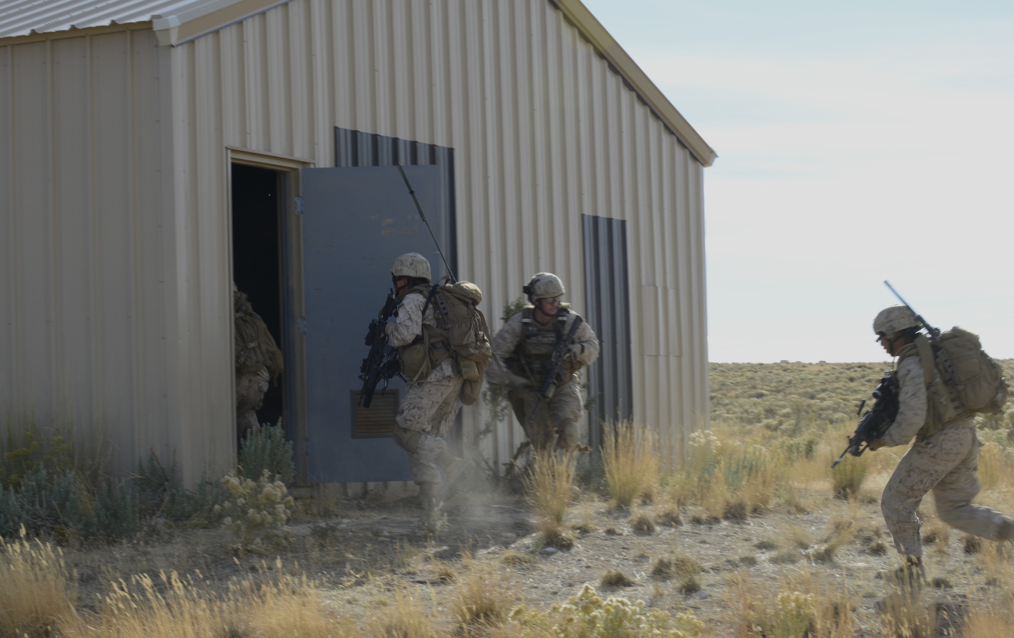 U.S. Marines from the 1st Air Naval Gunfire Liaison Company clear a building during Mountain Roundup 2013 Urban Operations training Oct 8, 2013, at the Juniper Butte range. The 1st ANGLICO team members also called in close air support during the exercise to re-qualify JTACs and to maintain proficiency in their ability to provide CAS, while training with another major coalition partner nation – Germany. (U.S. Air Force photo by Senior Airman Benjamin Sutton/RELEASED)