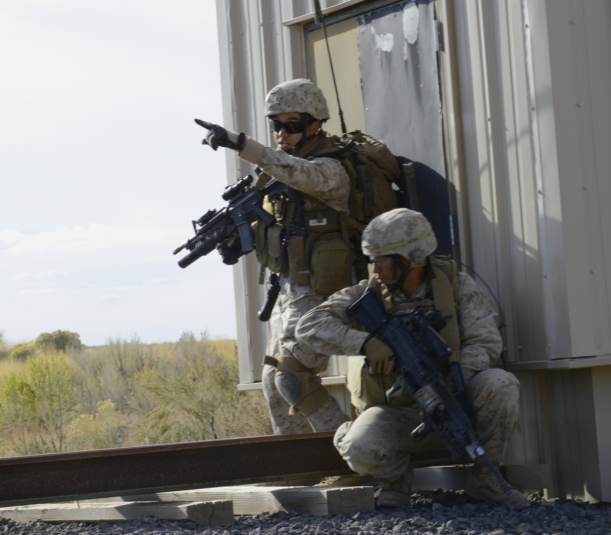 U.S. Marine Cpl. Daniel Soto, 1st Air Naval Gunfire Liaison Company forward air controller, points to a position while Cpl. Avila Sison, 1st ANGLICO forward observer, provides overwatch Oct 8, 2013, at the Juniper Butte range. During their last deployment, Marines assigned to 1st ANGLICO worked with the British Army, Afghan National Army, and several other units from various nations. (U.S. Air Force photo by Senior Airman Benjamin Sutton/RELEASED)