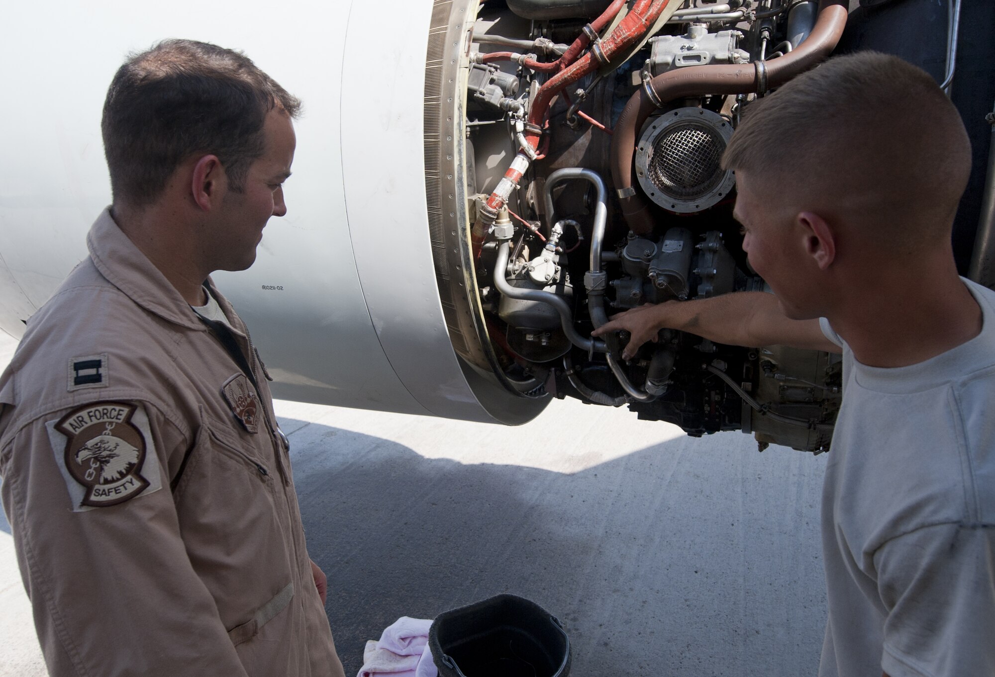 U.S. Air Force Maj. Brett VanderPas, 380th Air Expeditionary Wing chief of flight safety, talks with U.S. Air Force Airman 1st Class Joseph Harris, 380th Expeditionary Aircraft Maintenance Squadron jet engine mechanic, about a recent engine issue on a E-3 Sentry airborne warning and control system at an undisclosed location in Southwest Asia Sept. 23, 2013. Harris was working to fix the number 3 engine that went down during a mission in support of Operation Enduring Freedom. (U.S. Air Force photo by Staff Sgt. Jacob Morgan)