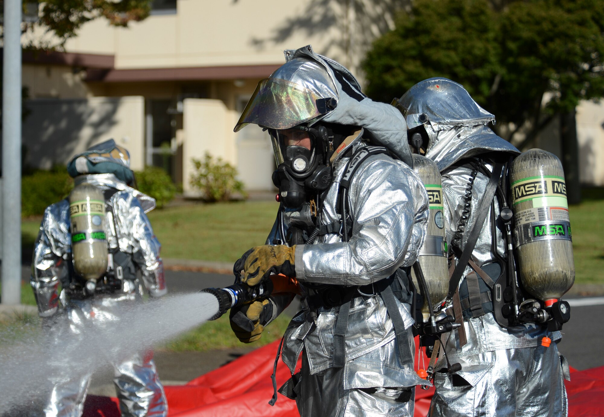 A 374th Civil Engineer Squadron fire fighter checks the pressure of the fire hose during an emergency management exercise as part of Readiness Week at Yokota Air Base, Japan, Oct. 10, 2013. The training allowed first responders a chance to practice their emergency response skills. (U.S. Air Force photo by Senior Airman Michael Washburn/Released)