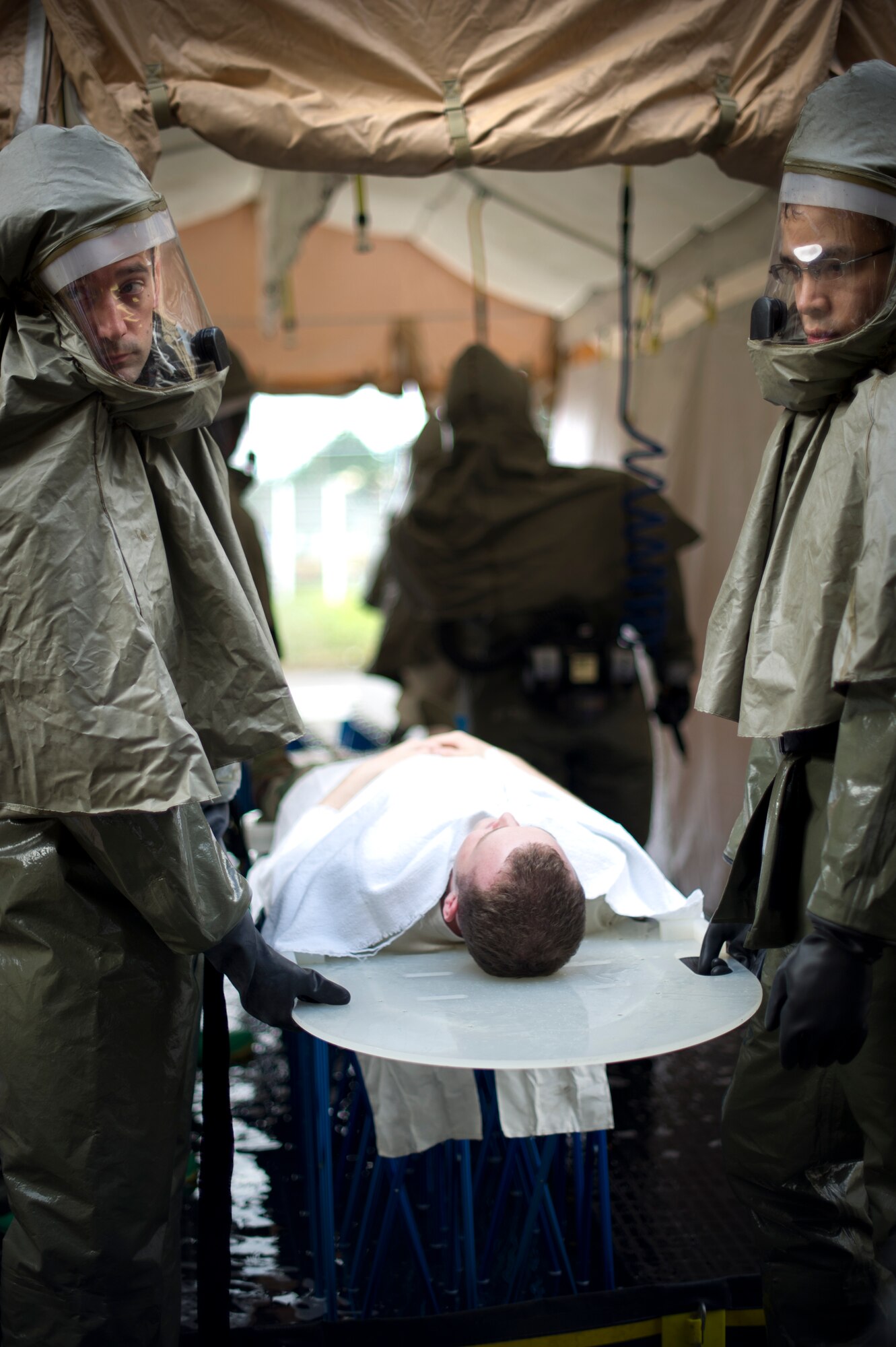 Members from the 374th Medical Group simulate decontaminating a victim during a simulated chemical spill as part of readiness week at Yokota Air base, Japan, Oct. 10, 2013. The training provided an opportunity for members of the Medical Group to hone lifesaving skills, and was conducted as part of wing-wide training during Readiness Week, which focused on enhancing the wing's ability to conduct its airlift mission under various conditions. (U.S. Air Force photo by Staff Sgt. Stacy Moless)
