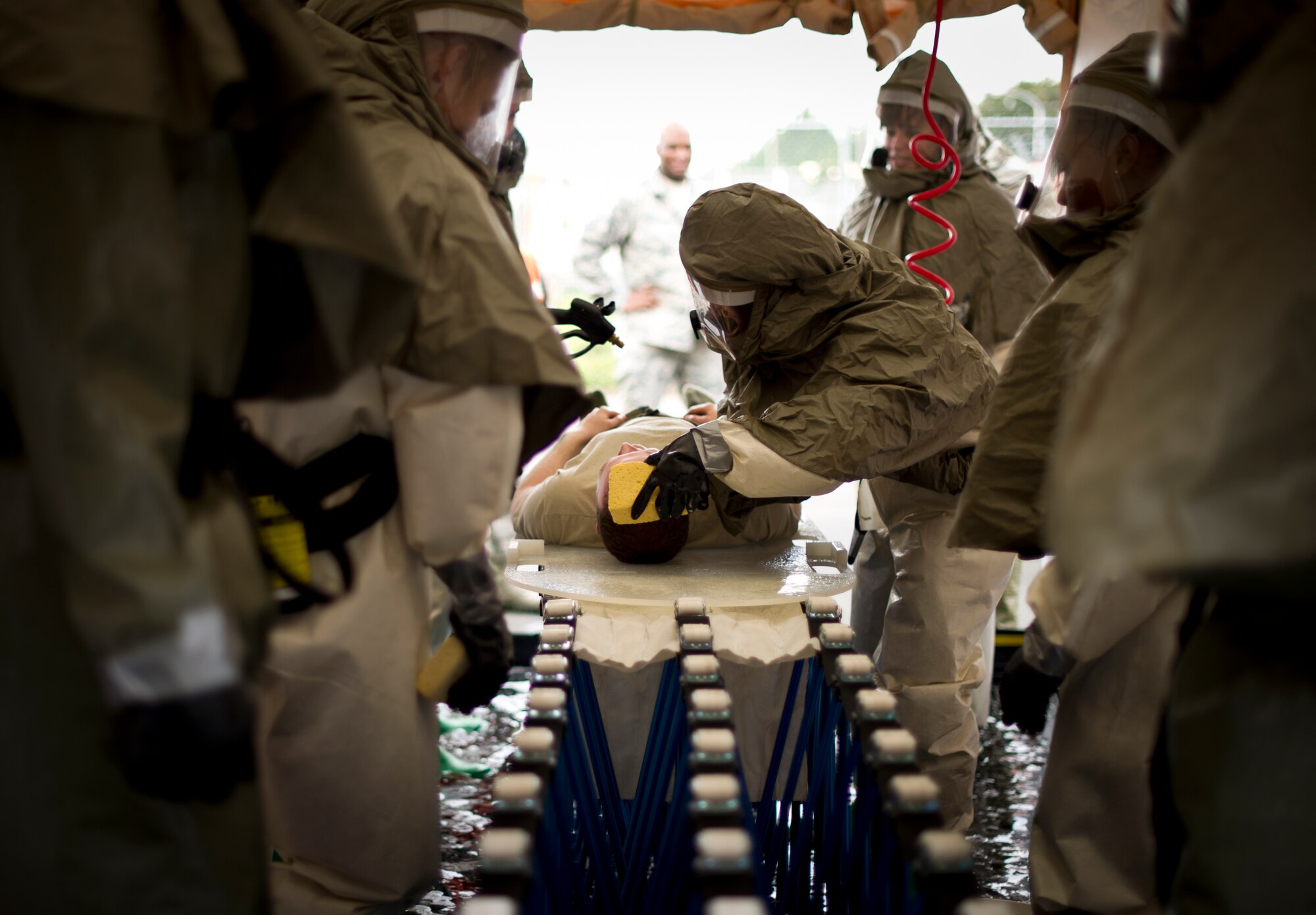 Members from the 374th Medical Group simulate decontaminating a victim during a simulated chemical spill as part of readiness week at Yokota Air base, Japan, Oct. 10, 2013. The training provided an opportunity for members of the Medical Group to hone lifesaving skills, and was conducted as part of wing-wide training during Readiness Week, which focused on enhancing the wing's ability to conduct its airlift mission under various conditions. (U.S. Air Force photo by Staff Sgt. Stacy Moless)