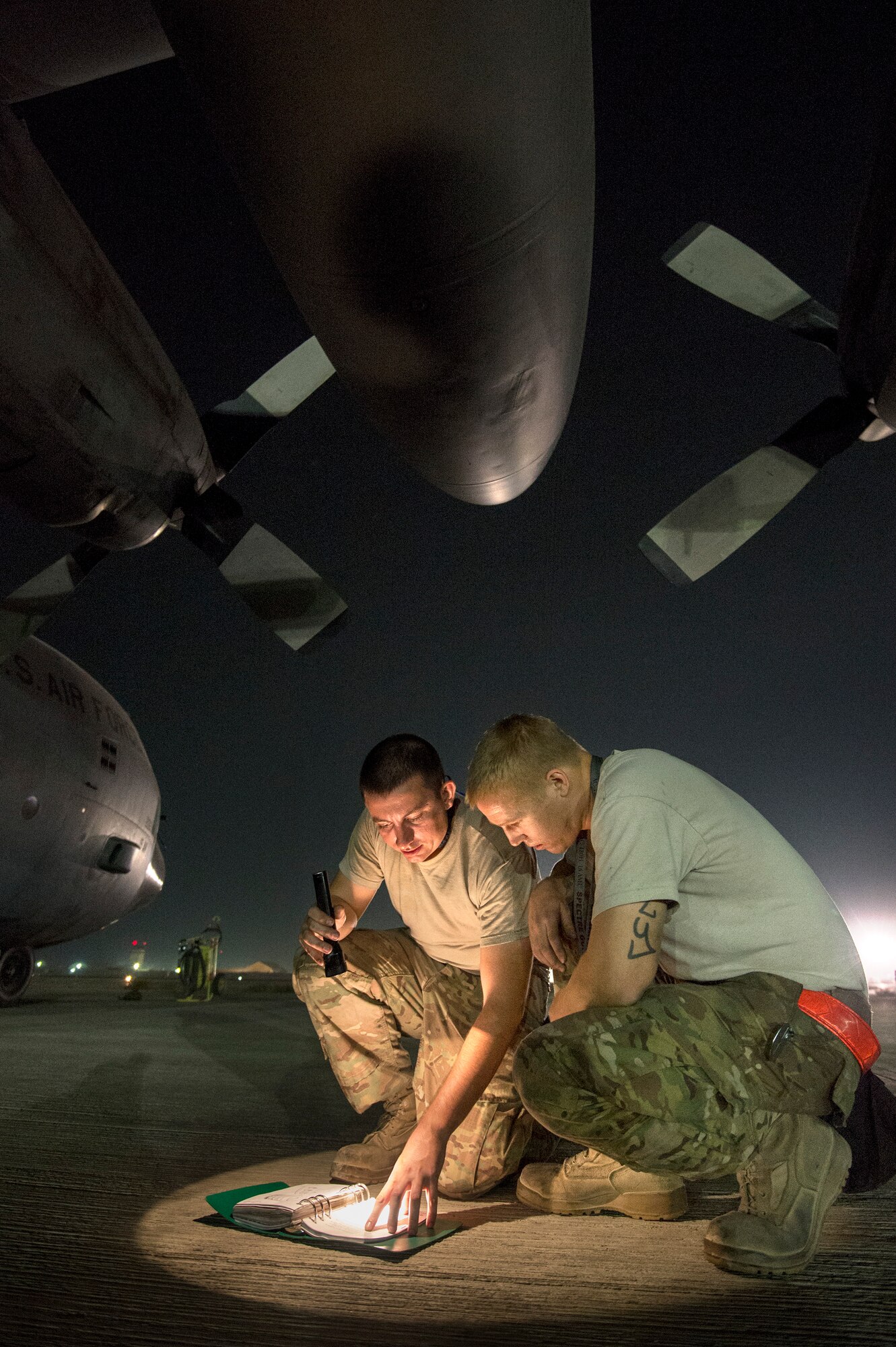 Staff Sgt. Kyle Law and Staff Sgt. Joshua Jorgensen, 774th Expeditionary Airlift Squadron crew chiefs, consult a technical order to troubleshoot a C-130H Hercules engine problem at Bagram Air Field, Parwan province, Afghanistan, Oct. 6, 2013. Hercules aircrew from the 774th EAS delivered 32 cargo bundles during two trips to remote drop zones in Ghazni province, Afghanistan. Law, a San Antonio, Texas, native, and Jorgensen, a Brentwood, Calif., native, are deployed from Little Rock Air Force Base, Ark. (USAF Photo/Master Sgt. Ben Bloker)