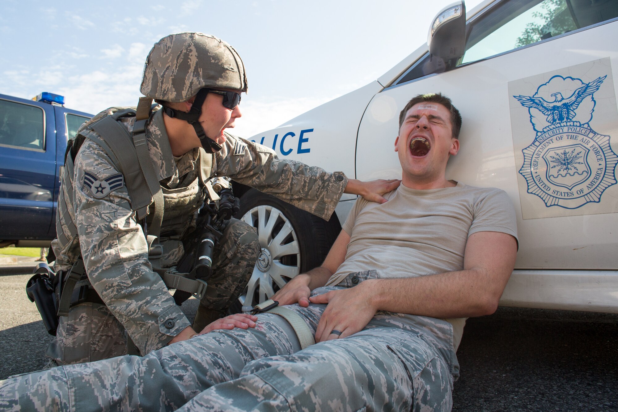 Senior Airman Madeline Salton, 374th Security Forces Squadron patrolman, assists a simulated injured victim during an active shooter scenario at Yokota Air Base, Japan, Oct. 10, 2013. The scenario allowed installation security forces to practice their skills in dealing with an active shooter scenario, and was conducted as part of wing-wide training during Readiness week, which focus on enhancing the wing's ability to conduct its airlift mission under various conditions. (U.S. Air Force photo by Osakabe Yasuo/Released)