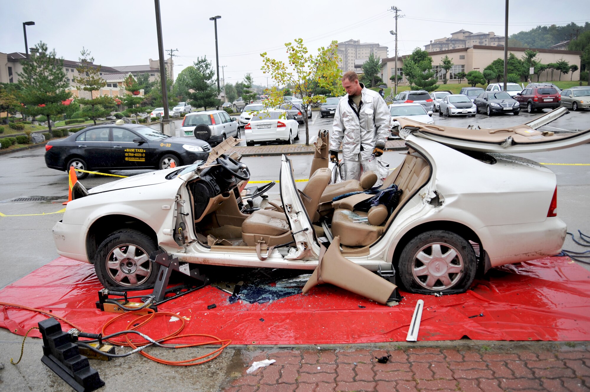 Senior Airman David Easterlund, 51st Civil Engineer Squadron fire and emergency services flight firefighter, examines the vehicle that was used during a vehicle extrication demonstration at Osan Air Base, Republic of Korea, Oct. 8, 2013. Firefighters showcased the steps they would take to remove a victim from a vehicle involved in a serious accident as a way to kick off fire prevention week. (U.S. Air Force photo/Staff Sgt. Emerson Nuñez)