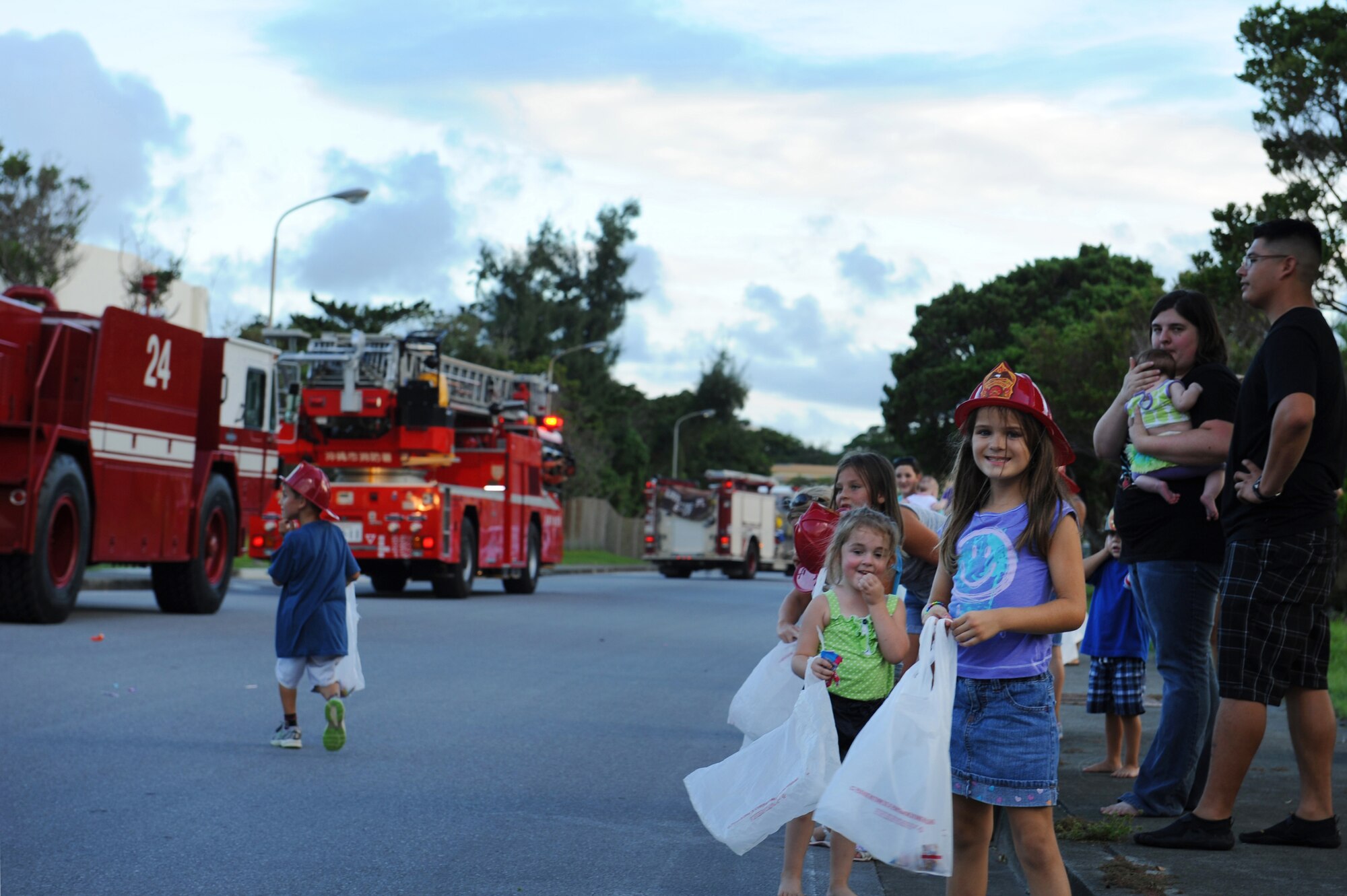 Children watch as members from the 18th Civil Engineer Squadron drive down a street during the Fire Prevention Week parade on Kadena Air Base, Japan, Oct. 9, 2013. The parade was part of a week-long effort to promote fire safety and prevention to members of Team Kadena. (U.S. Air Force photo by Airman 1st Class Keith James)