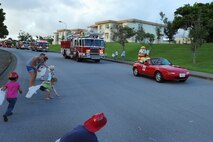 Children go after candy being tossed out of fire vehicles during a fire prevention parade on Kadena Air Base, Japan, Oct. 9, 2013. The Kadena fire department led the parade through base housing, waving and tossing out candy to swarmng children and on-lookers as part of a week-long effort to promote fire safety and prevention. (U.S. Air Force photo by Airman 1st Class Keith James)