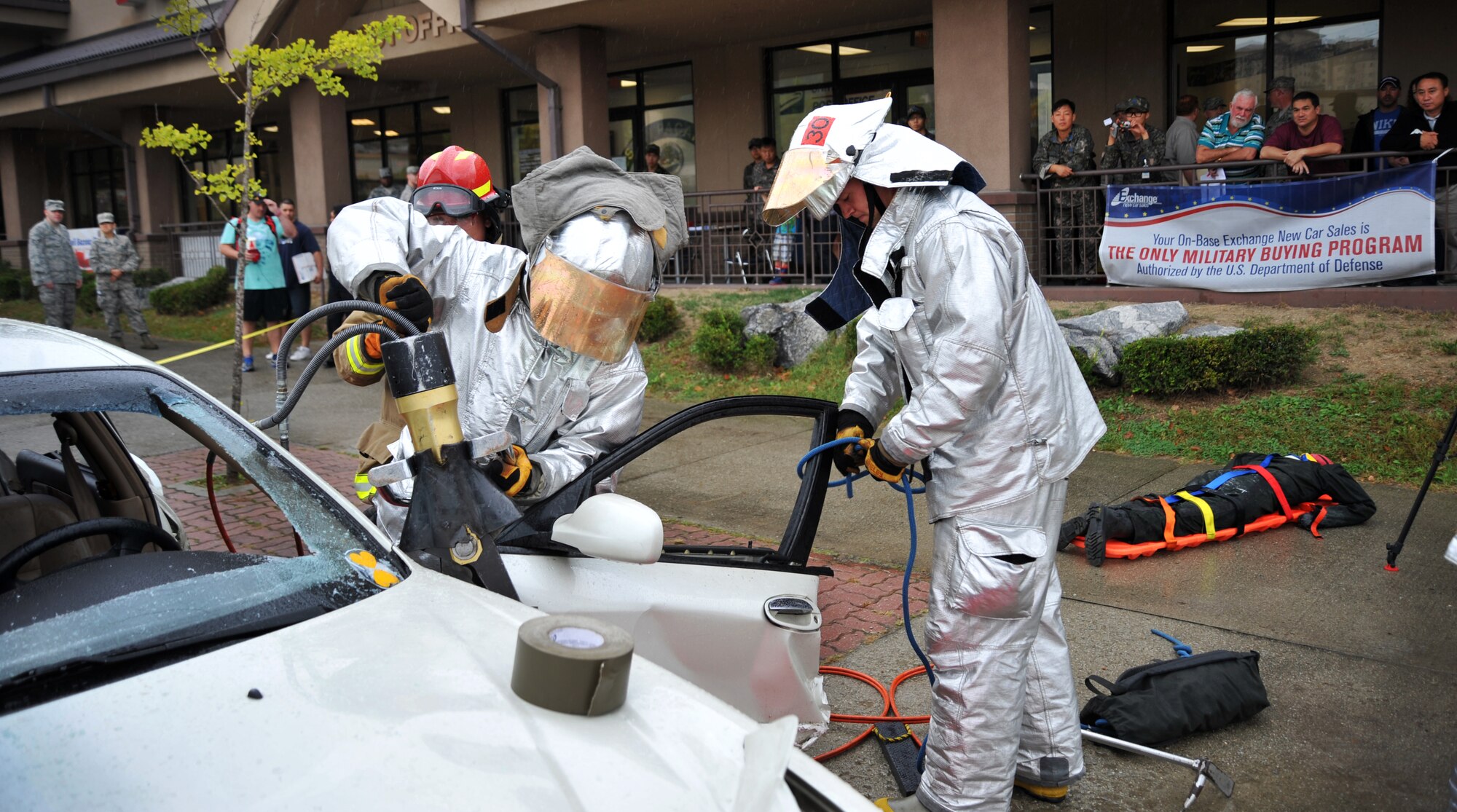 Senior Airmen Robert McCallon, left, and David Easterlund, 51st Civil Engineer Squadron fire and emergency services flight firefighters, remove the driver side door during a vehicle extrication demonstration at Osan Air Base, Republic of Korea, Oct. 8, 2013. The demonstration was held to kick off fire prevention week, which is observed annually on the anniversary of the Great Chicago Fire. (U.S. Air Force photo/Staff Sgt. Emerson Nuñez)