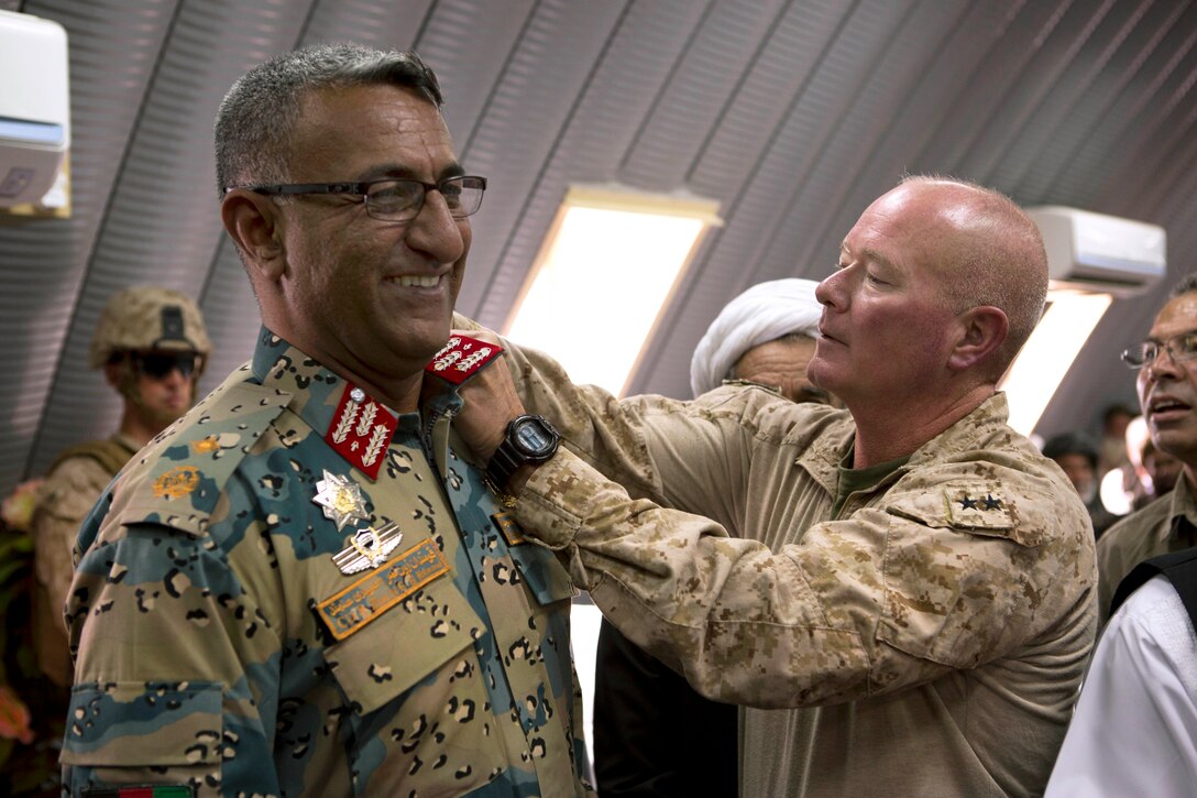 U.S Marine Corps Maj. Gen. Walter L. Miller Jr., right, commanding general of Regional Command Southwest, fixes the new rank insignia on Afghan border police Col. Sultan Mahmood during a ceremony at police headquarters in Lashkar Gah in Afghanistan's Helmand province, Oct. 8, 2013.