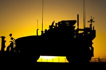 The sun sets behind a Mine Resistant, Ambush Protected vehicle staged at the motor pool for Combat Logistics Regiment 2, Regional Command (Southwest), at Camp Dwyer, Helmand province, Afghanistan, Sept. 30, 2013. A combat logistics patrol of more than forty vehicles set out from the base early the next morning to return supplies and equipment to Camp Leatherneck, Afghanistan.