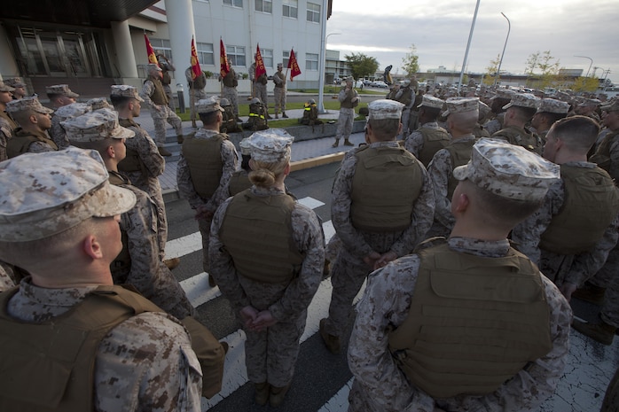 Service members with Headquarters and Headquarters Squadron gather around Lt. Col. F. Lance Lewis in front of building one after their 10 kilometer hike Sept. 5, 2013. The conditioning hikes were developed to prepare service members for the 17.75 kilometer hike in honor of the Marine Corps Birthday Ball. 