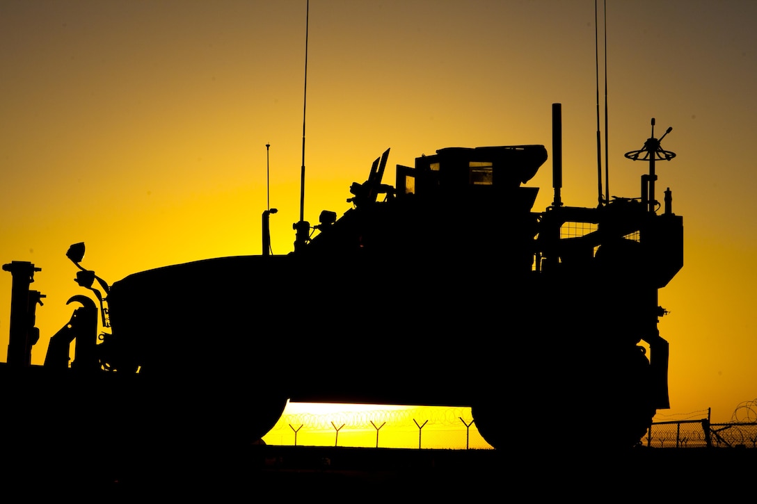 The sun sets behind a Mine Resistant, Ambush Protected vehicle staged at the motor pool for Combat Logistics Regiment 2, Regional Command (Southwest), at Camp Dwyer, Helmand province, Afghanistan, Sept. 30, 2013. A combat logistics patrol of more than forty vehicles set out from the base early the next morning to return supplies and equipment to Camp Leatherneck, Afghanistan.