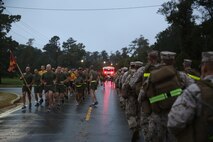 Service members with Combat Logistics Battalion 2, Combat Logistics Regiment 2, 2nd Marine Logistics Group (right) hike past Marines and sailors with Combat Logistics Regiment 25, 2nd MLG (left), who participated in a regimental run aboard Camp Lejeune, N.C., Oct. 10, 2013. The two units encouraged and teased each other as they conducted their training on the same road. 